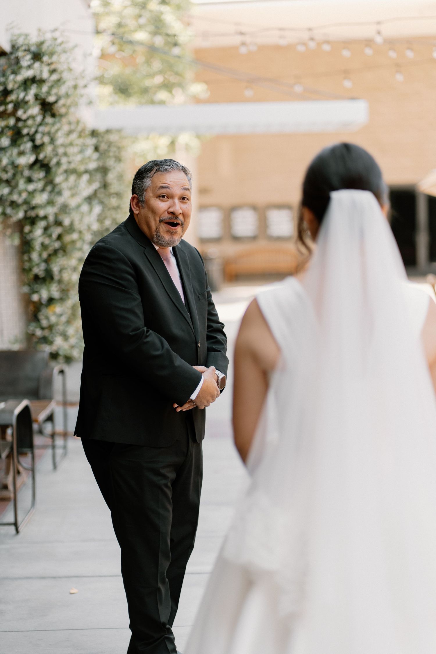 Father reacts with joy and surprise seeing daughter in wedding dress during emotional first look.