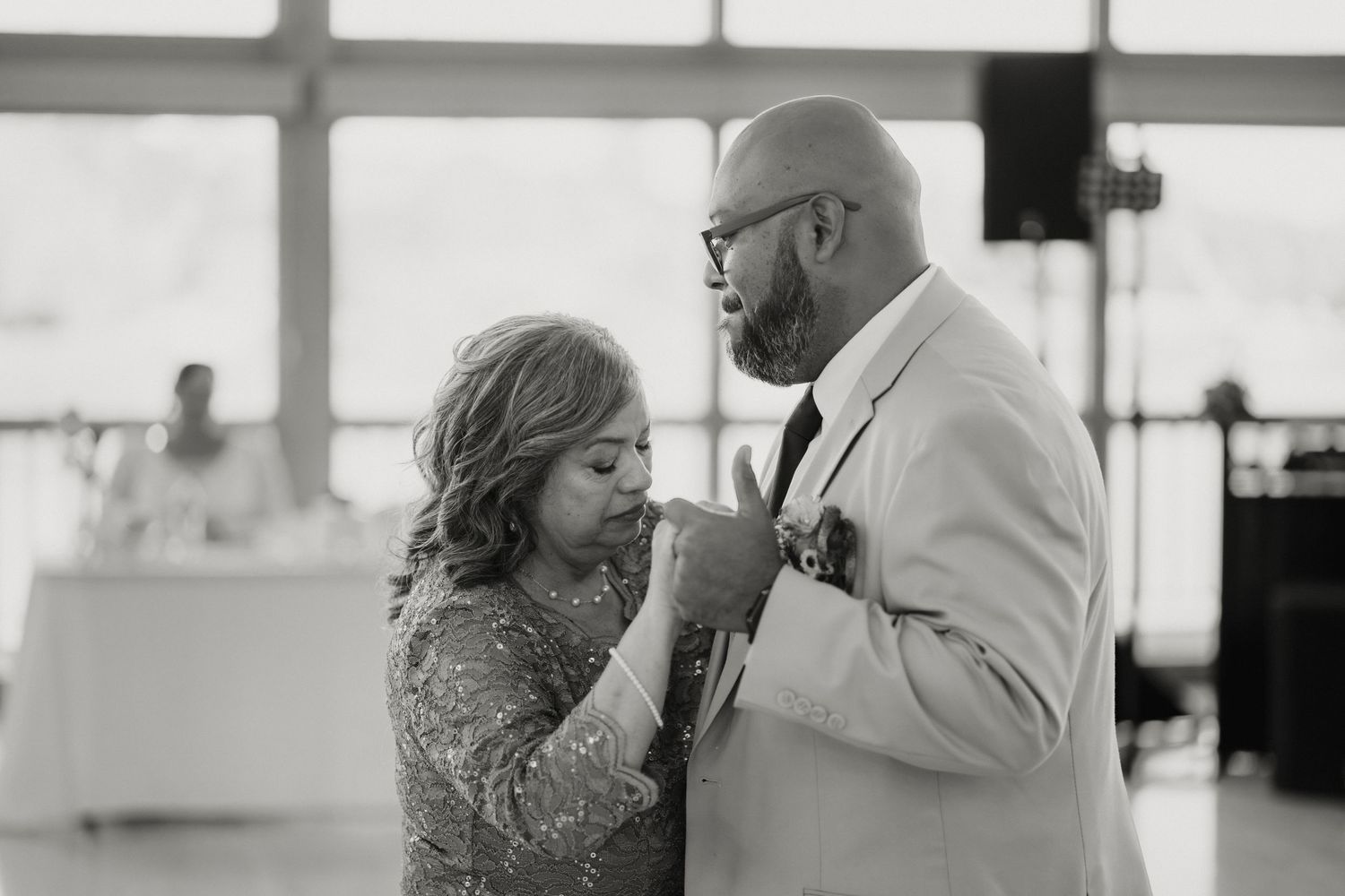 Black and white photo of a couple sharing a tender moment on the dance floor at an elegant wedding reception.