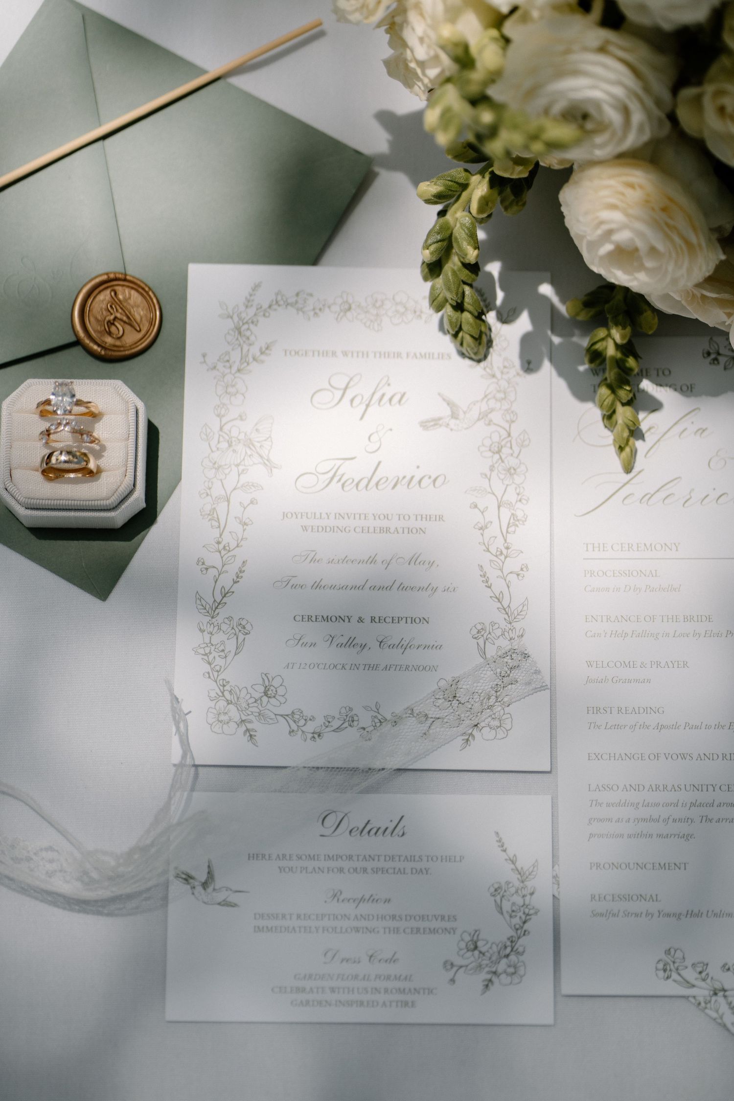Wedding stationery flat lay featuring Sofia and Federico invitation suite with sage envelope, wax seal, and rings.