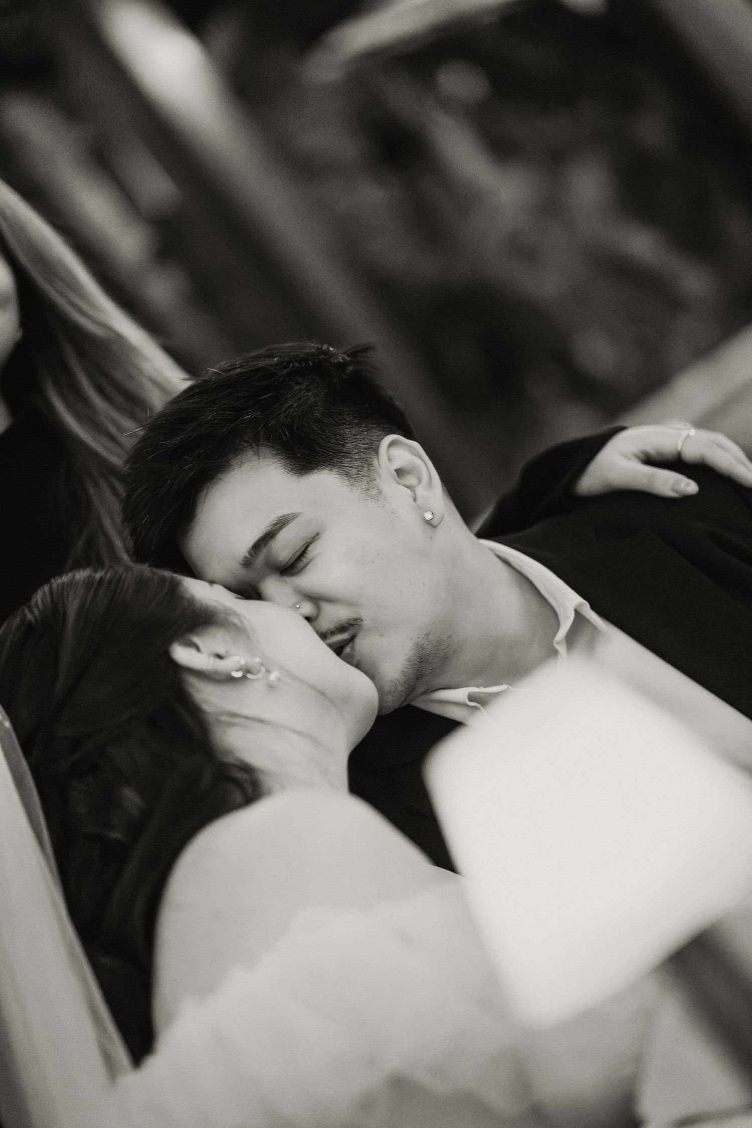 Black and white romantic close-up of bride and groom sharing an intimate kiss.