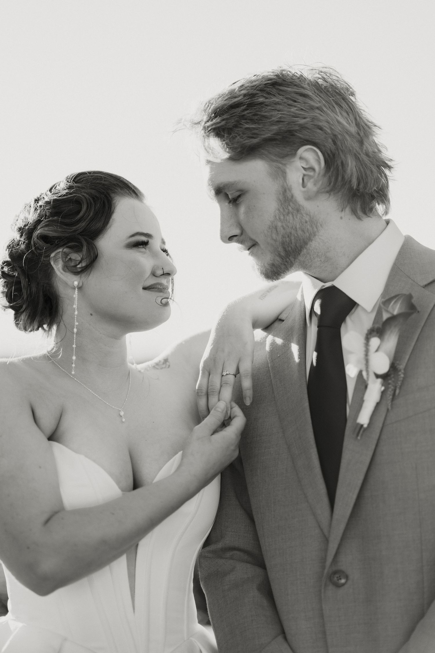 Black and white close-up of smiling bride and groom sharing a tender moment on their wedding day.
