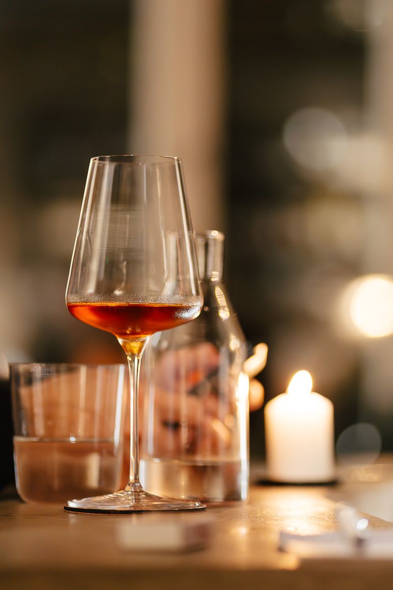 Glass of rosé wine on a candlelit table at Pinocchio, wine bar in Helsinki