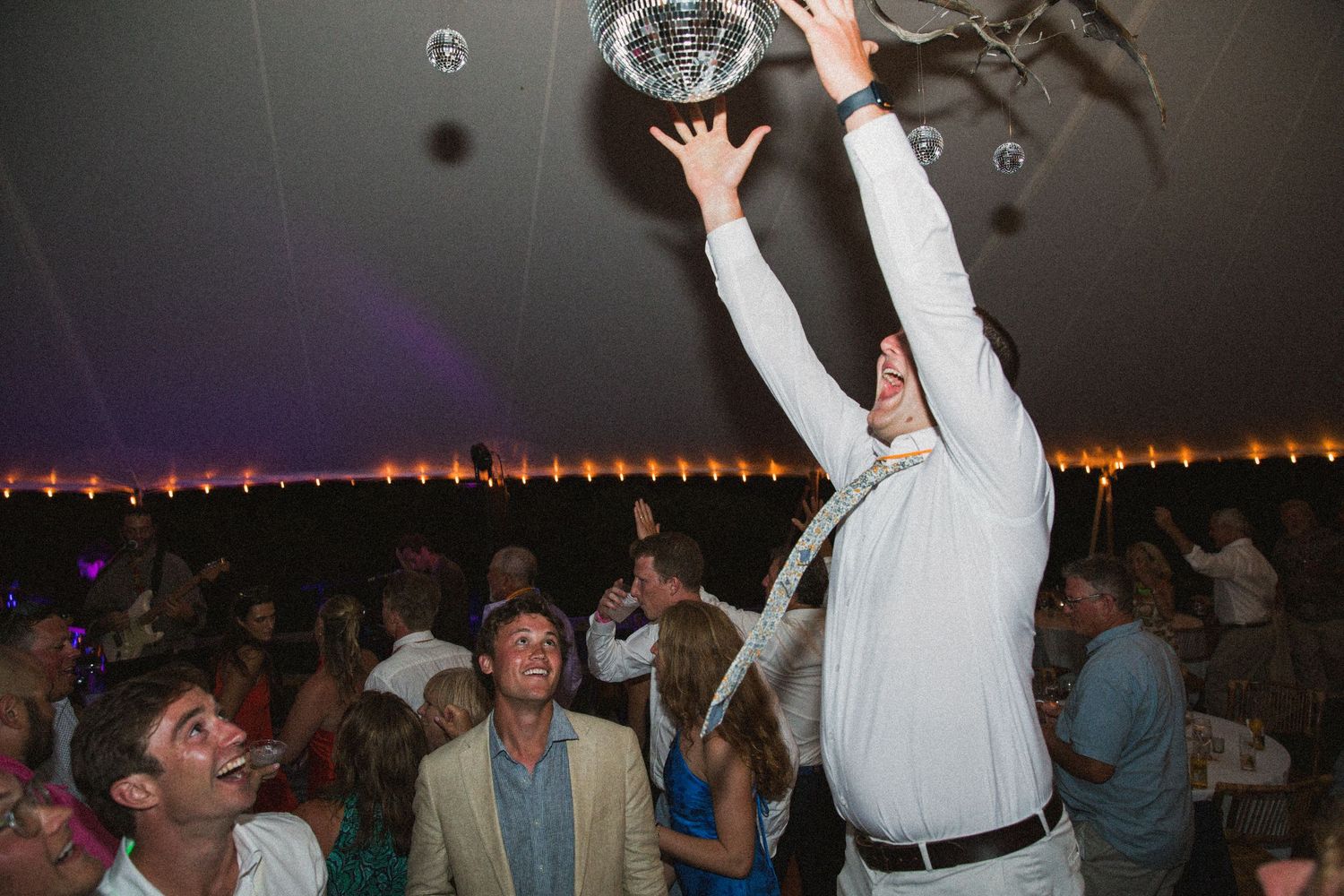 Energetic dancing and celebration at a wedding reception with guests enjoying the festivities.