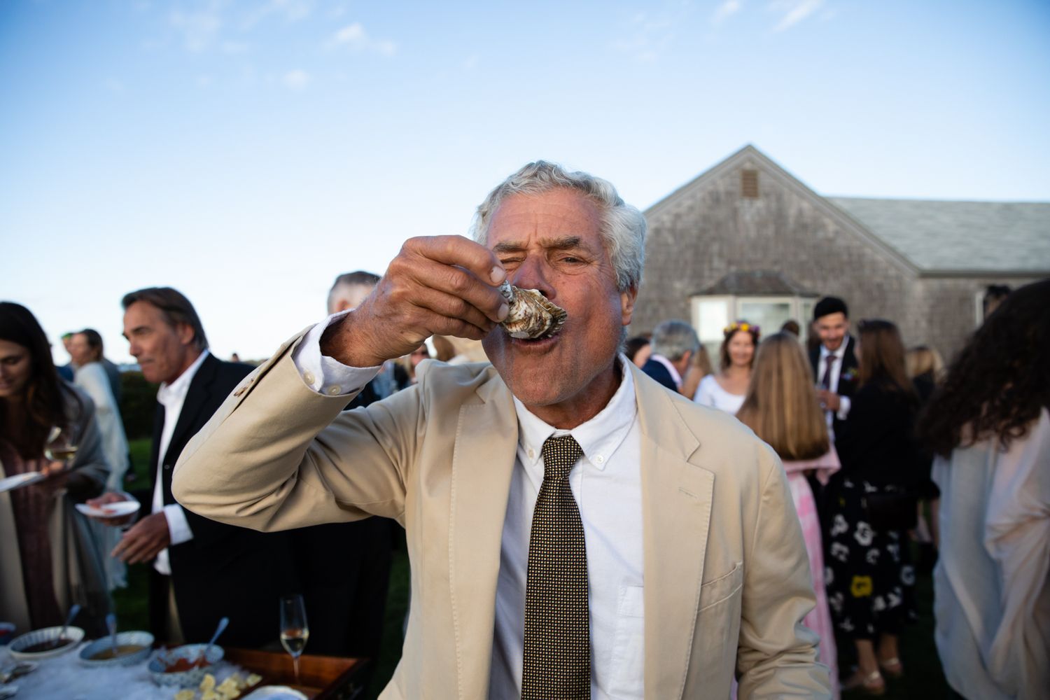 Guest enjoying oysters at an outdoor wedding reception.