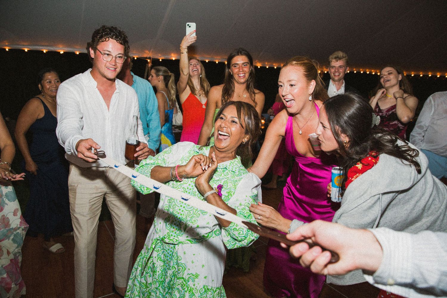 Wedding reception dance floor filled with guests dancing and celebrating.