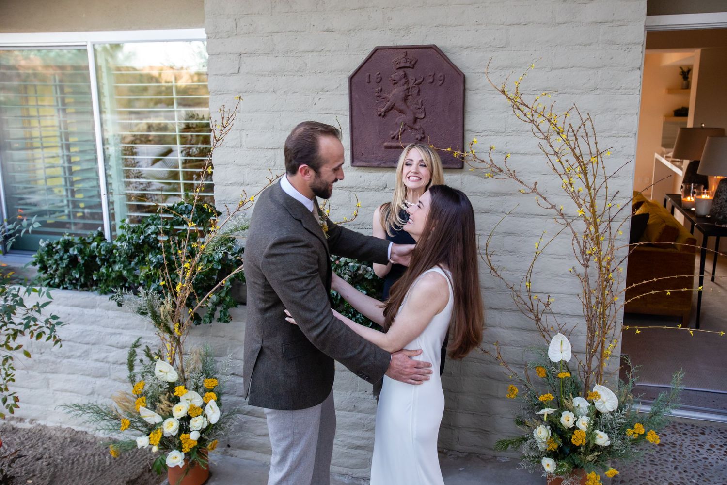 An emotional proposal scene unfolds against a white brick backdrop with yellow flower arrangements.