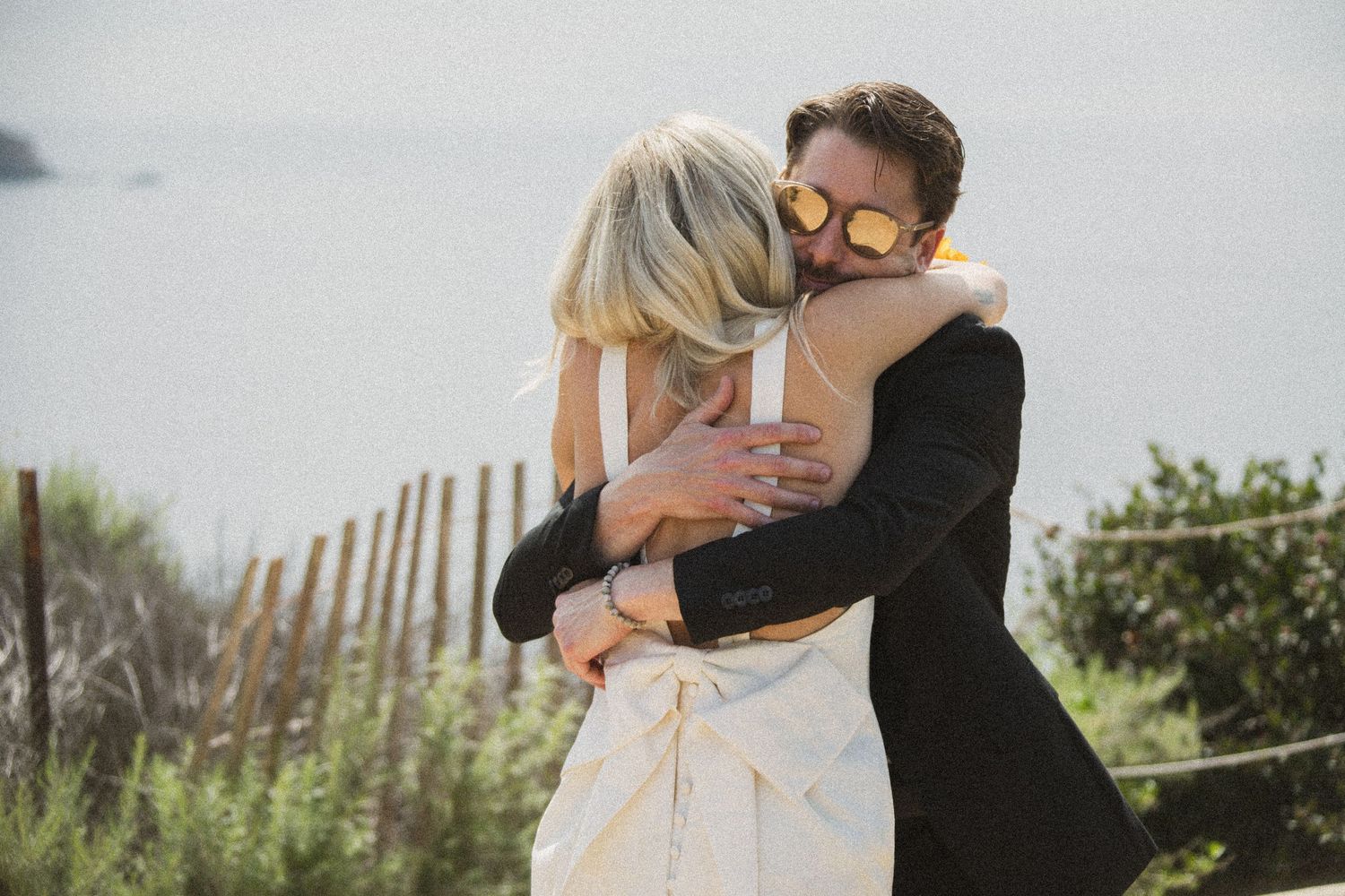 Candid wedding moments captured on a sunny outdoor path.