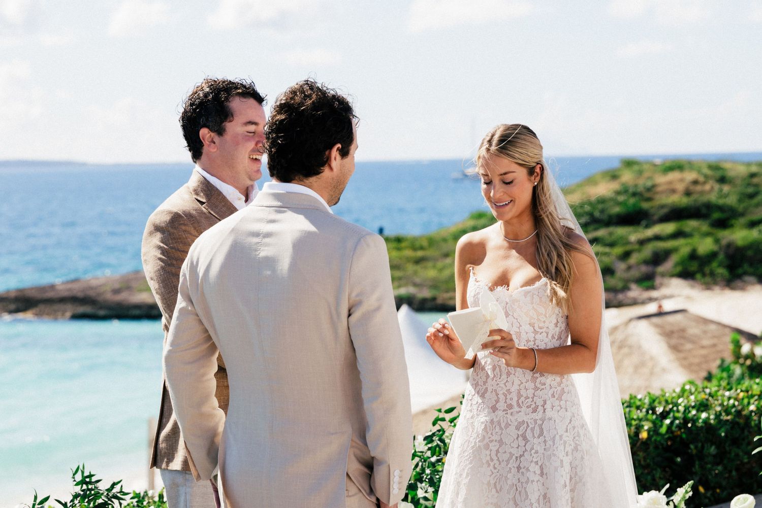 Wedding party gathered on a scenic coastal overlook with lush greenery and ocean views.