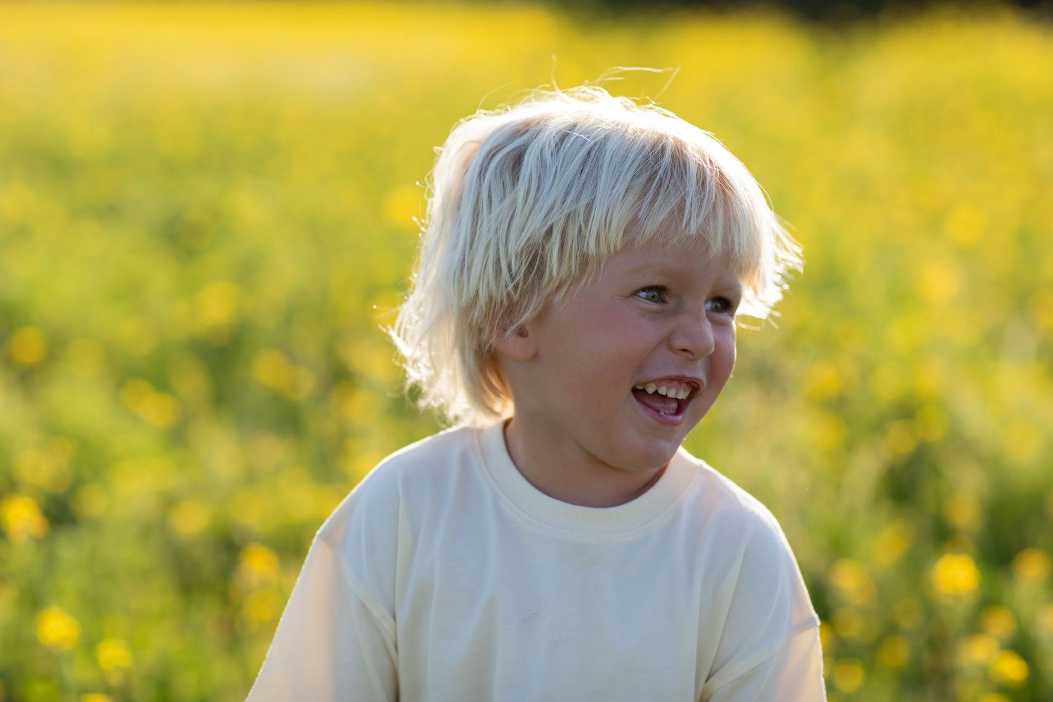 Joyful expressions captured in a series of outdoor portraits among yellow flowers.