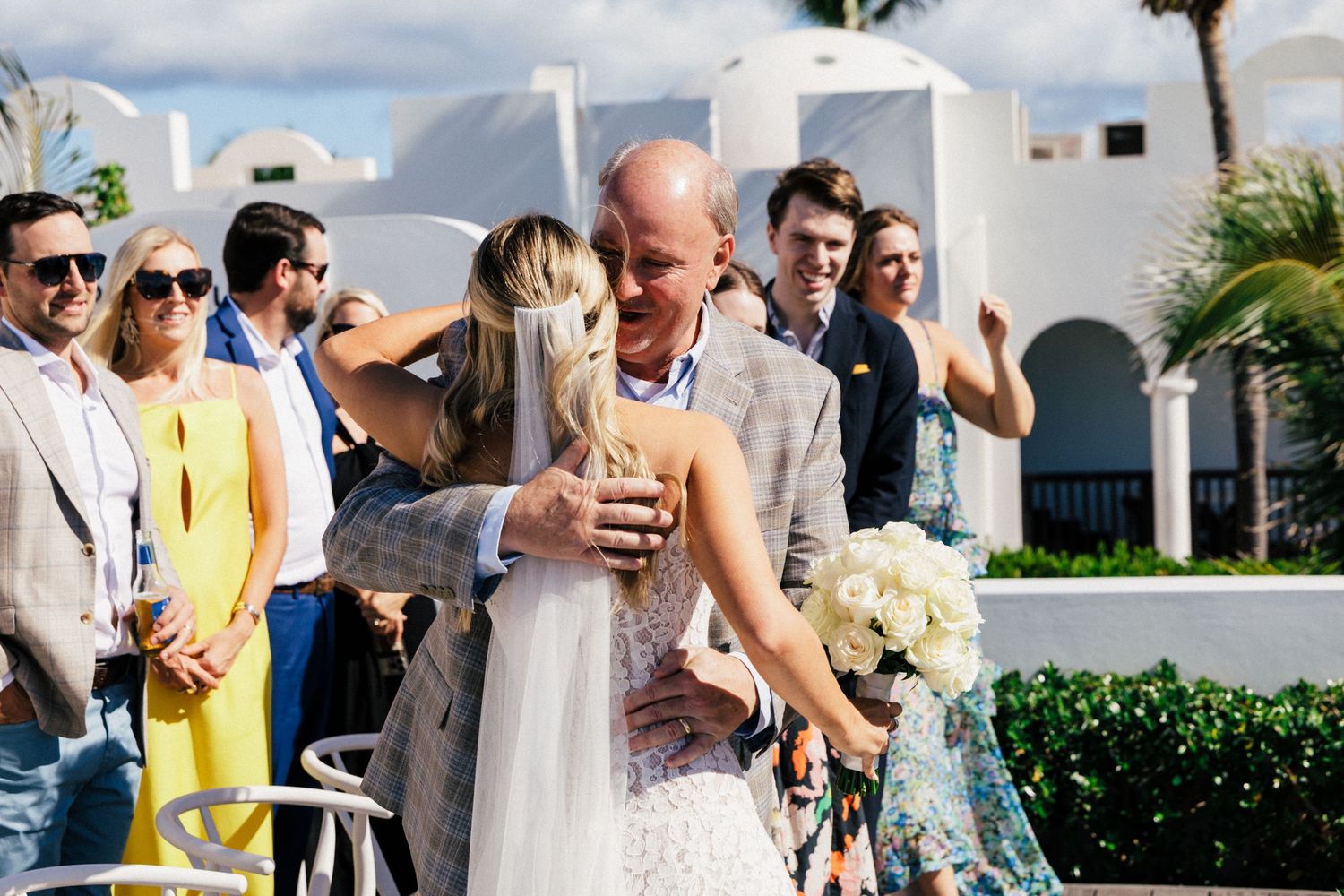 Wedding celebration on coastal terrace with guests in formal attire.