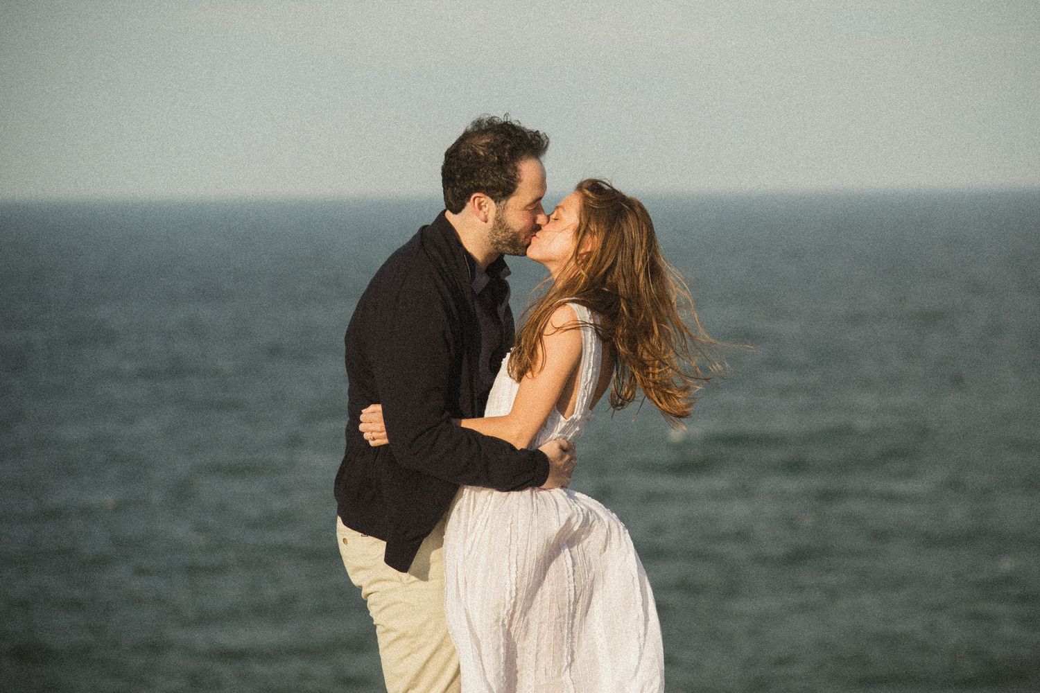 A romantic seaside moment captured with dramatic ocean views.