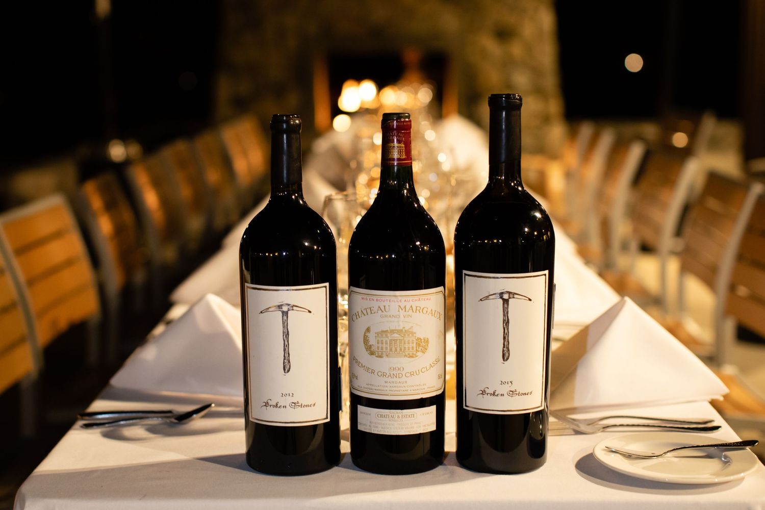 Wine bottles arranged on an elegant dinner table with soft lighting.