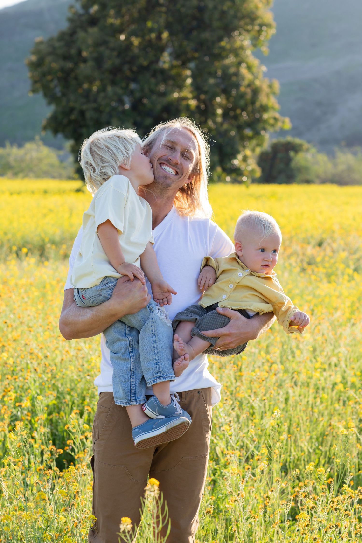 Candid family interactions in a golden meadow during sunset.
