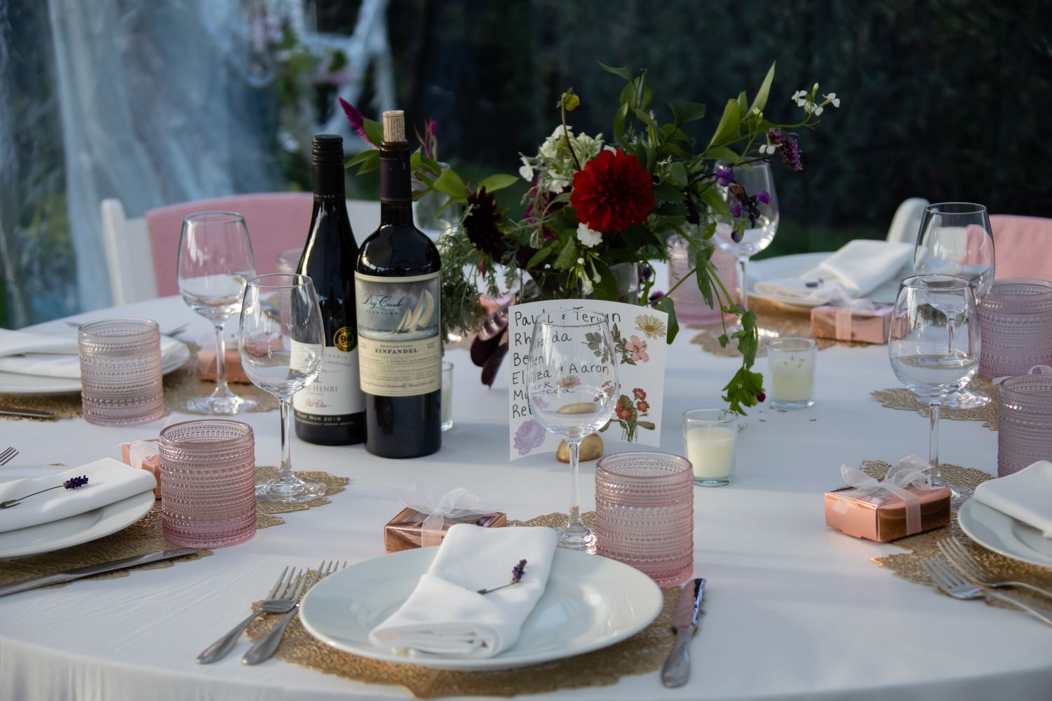 Romantic wedding reception table with pink accents and floral centerpieces.
