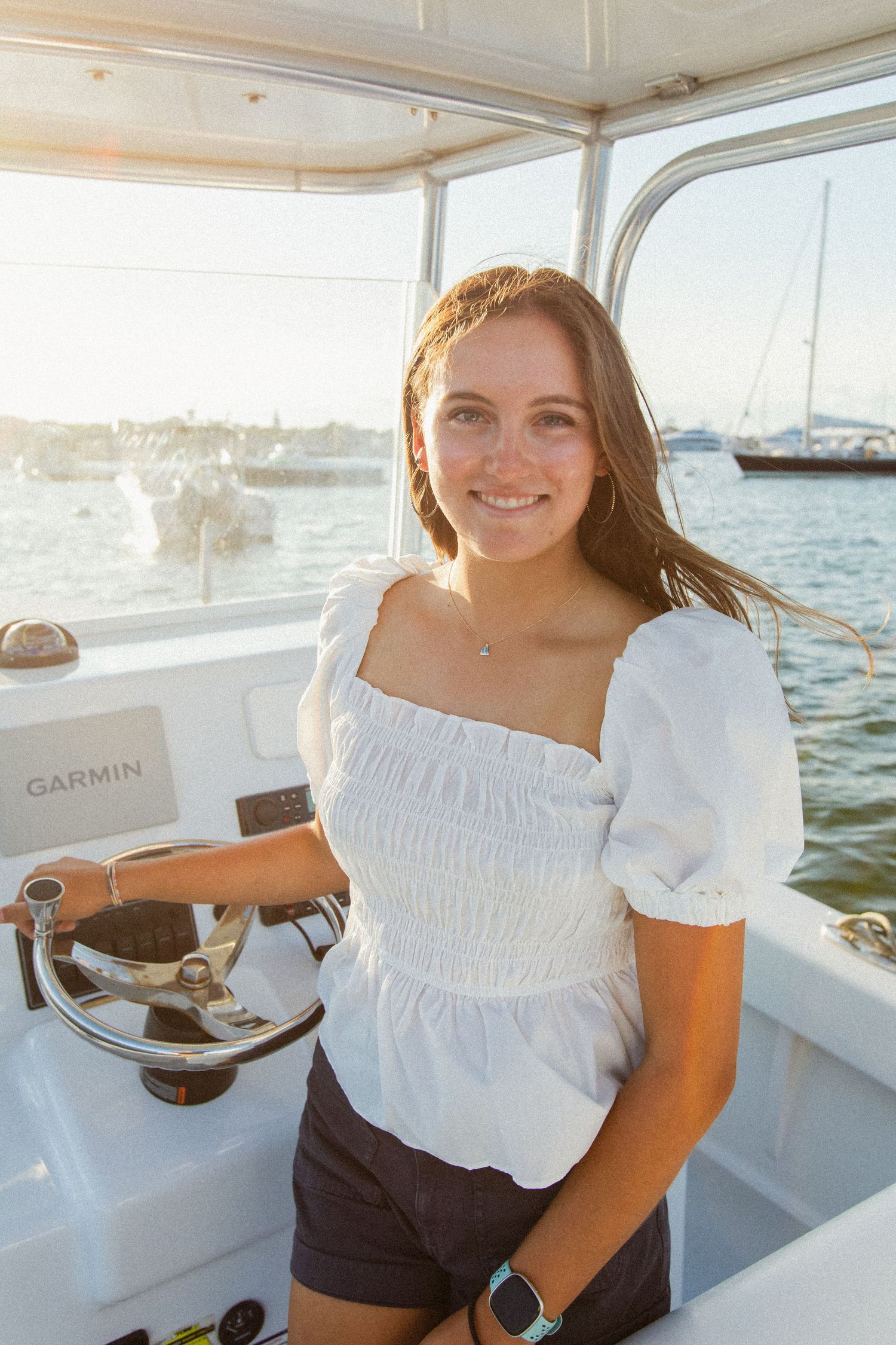 Nautical themed photoshoot on a boat with Garmin equipment visible.