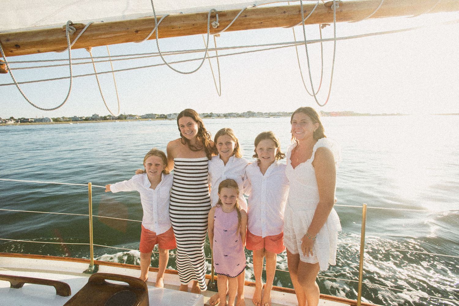 Happy group gathered on deck of a sailing boat during a summer excursion.