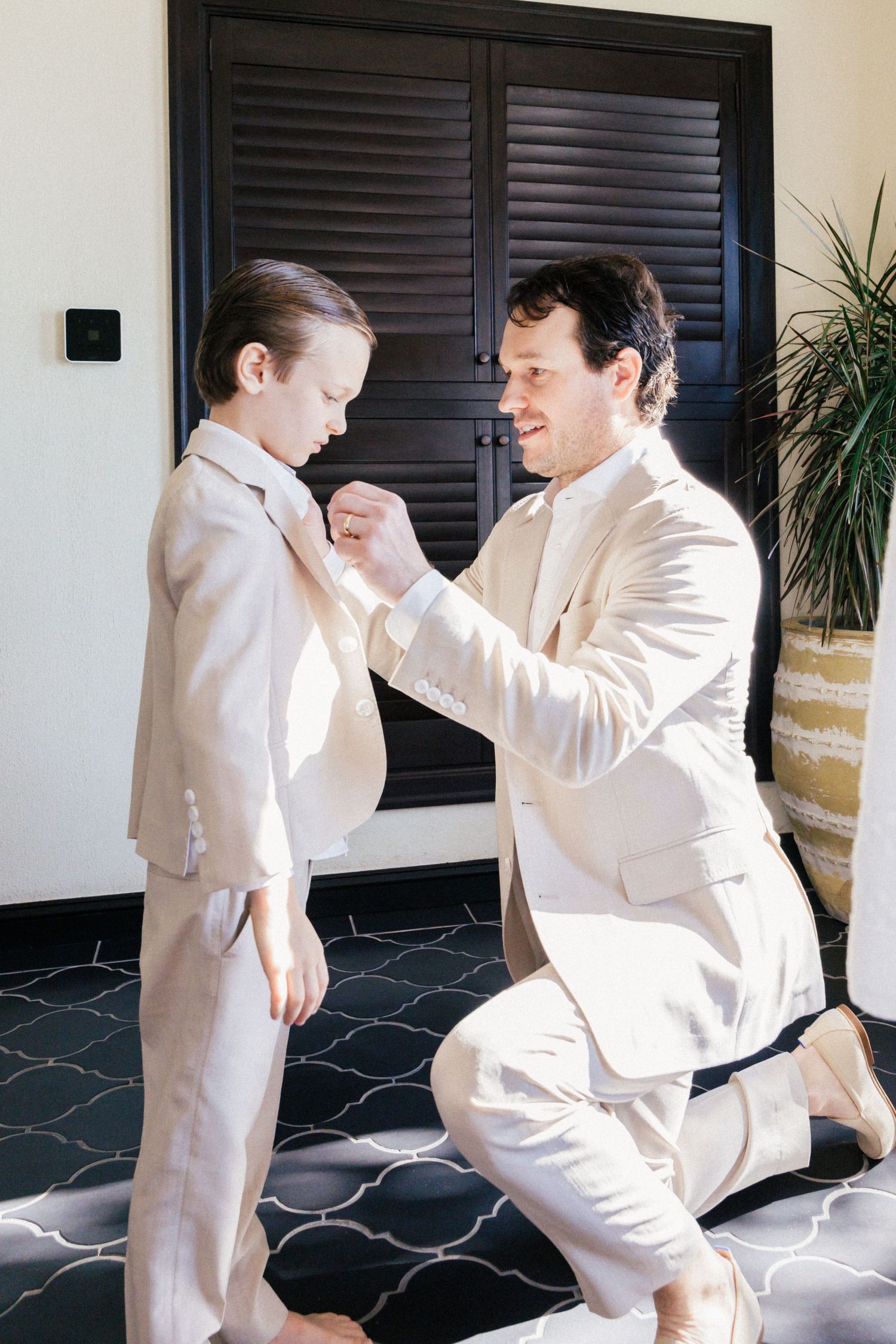 Two people in white outfits practicing martial arts moves on a patterned floor.