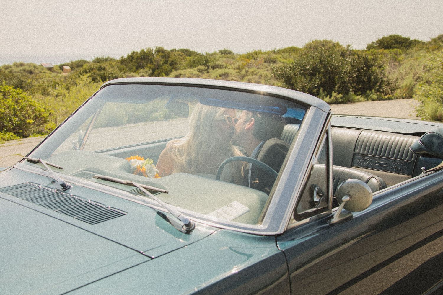 Blue classic convertible car photographed from multiple angles on a coastal highway.