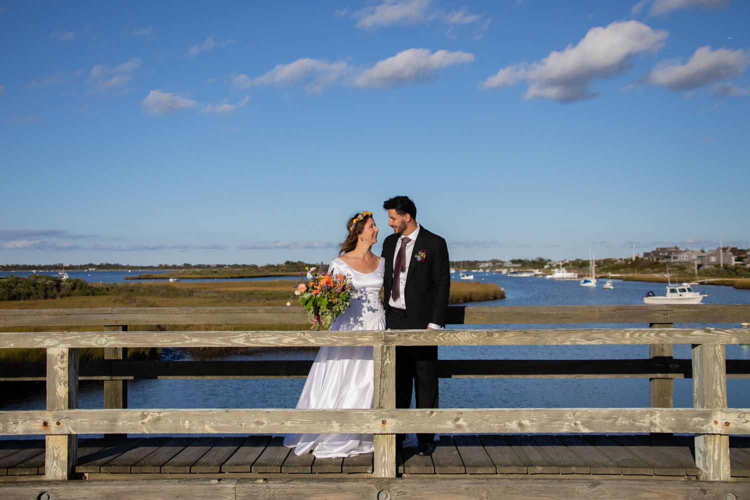 Wedding photography session on a scenic waterfront dock during a sunny day.