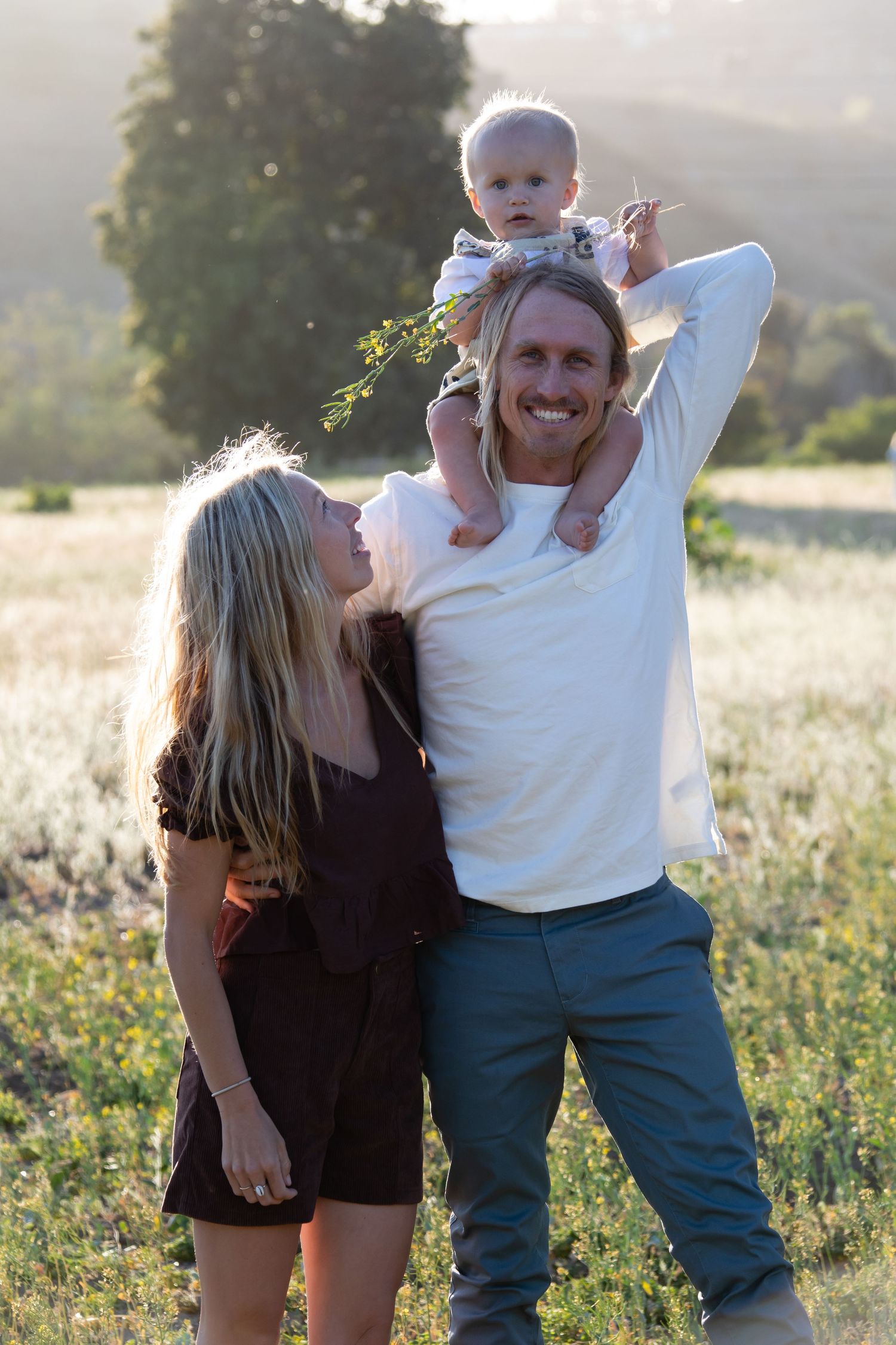 Playful outdoor photo session in a wildflower meadow at sunset.