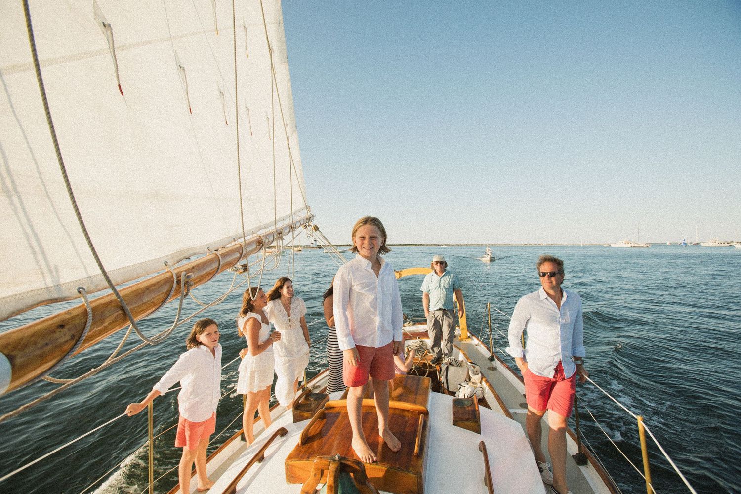 Sailing adventure captures multiple passengers enjoying time on a classic wooden vessel.