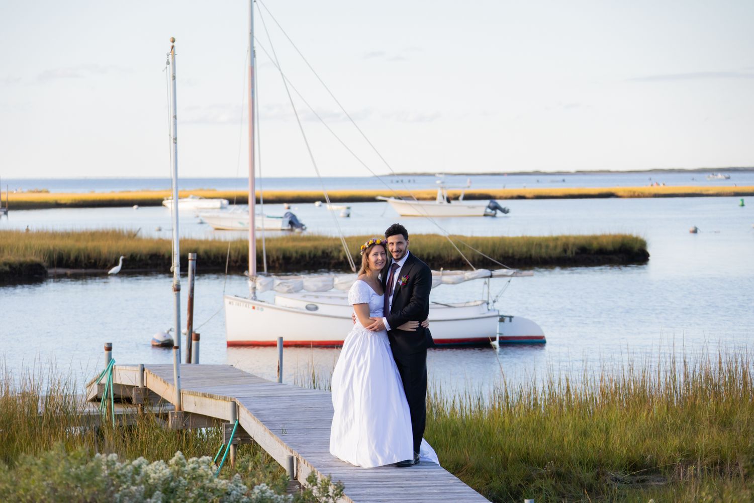 Coastal dock wedding photos with sailboats and marsh grass in the background.
