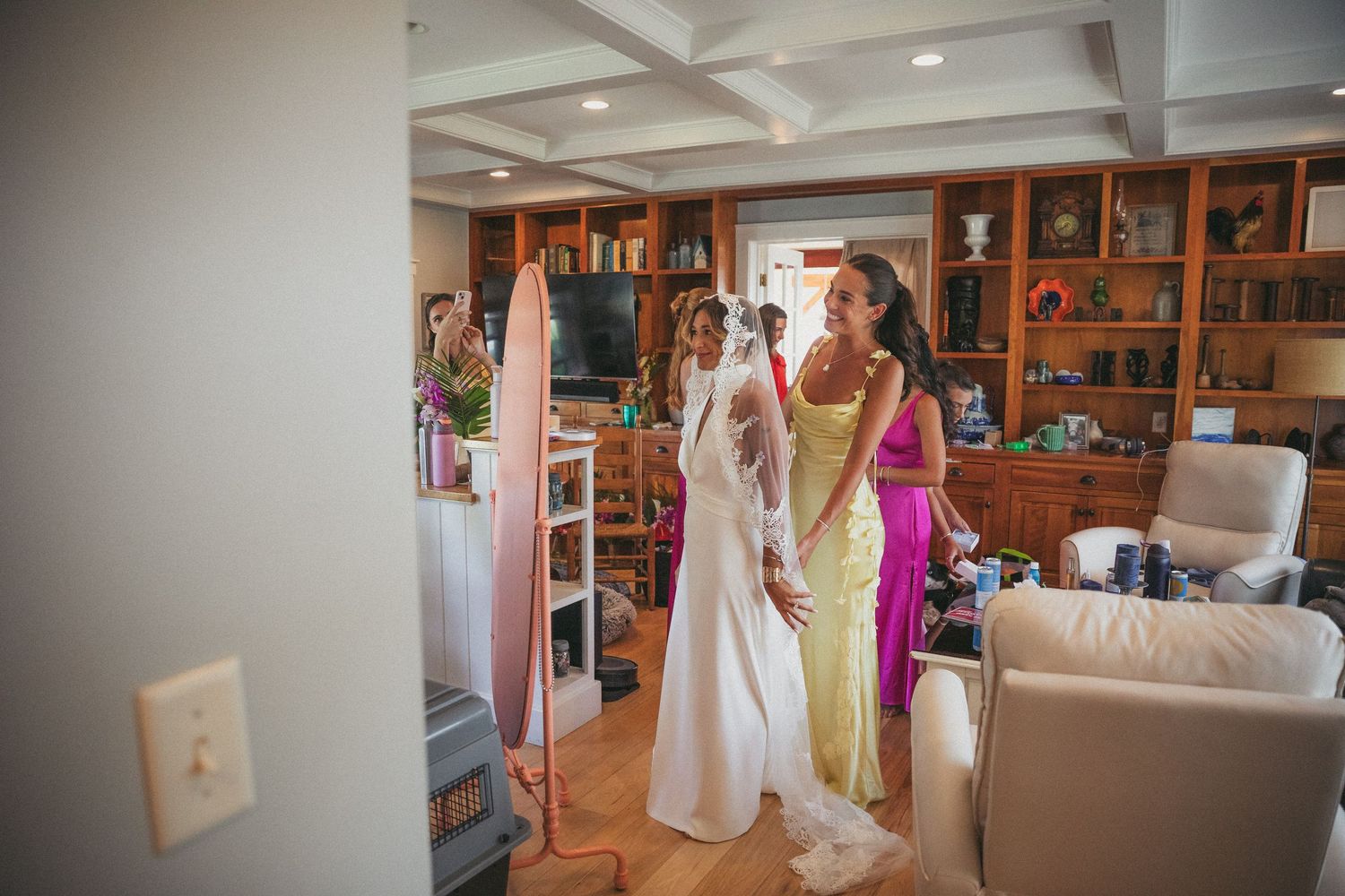 Wedding dress preparations in a cozy room with wooden built-in shelving.