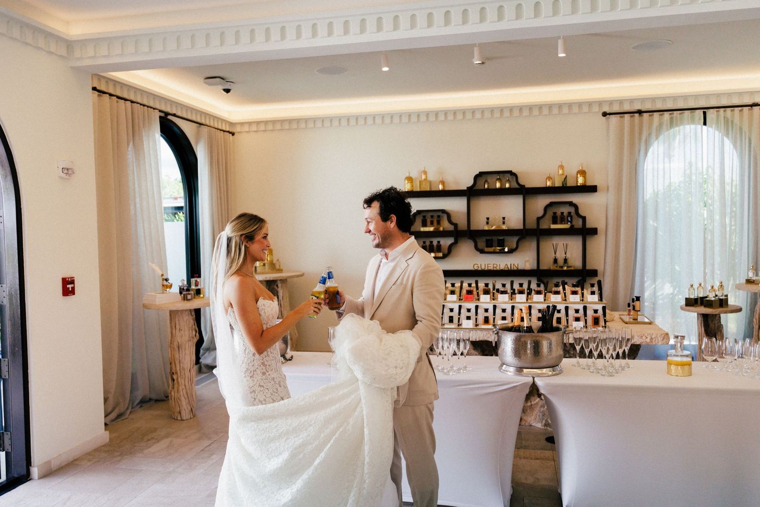 Interior view of an elegant white reception venue with crown molding and chandeliers.