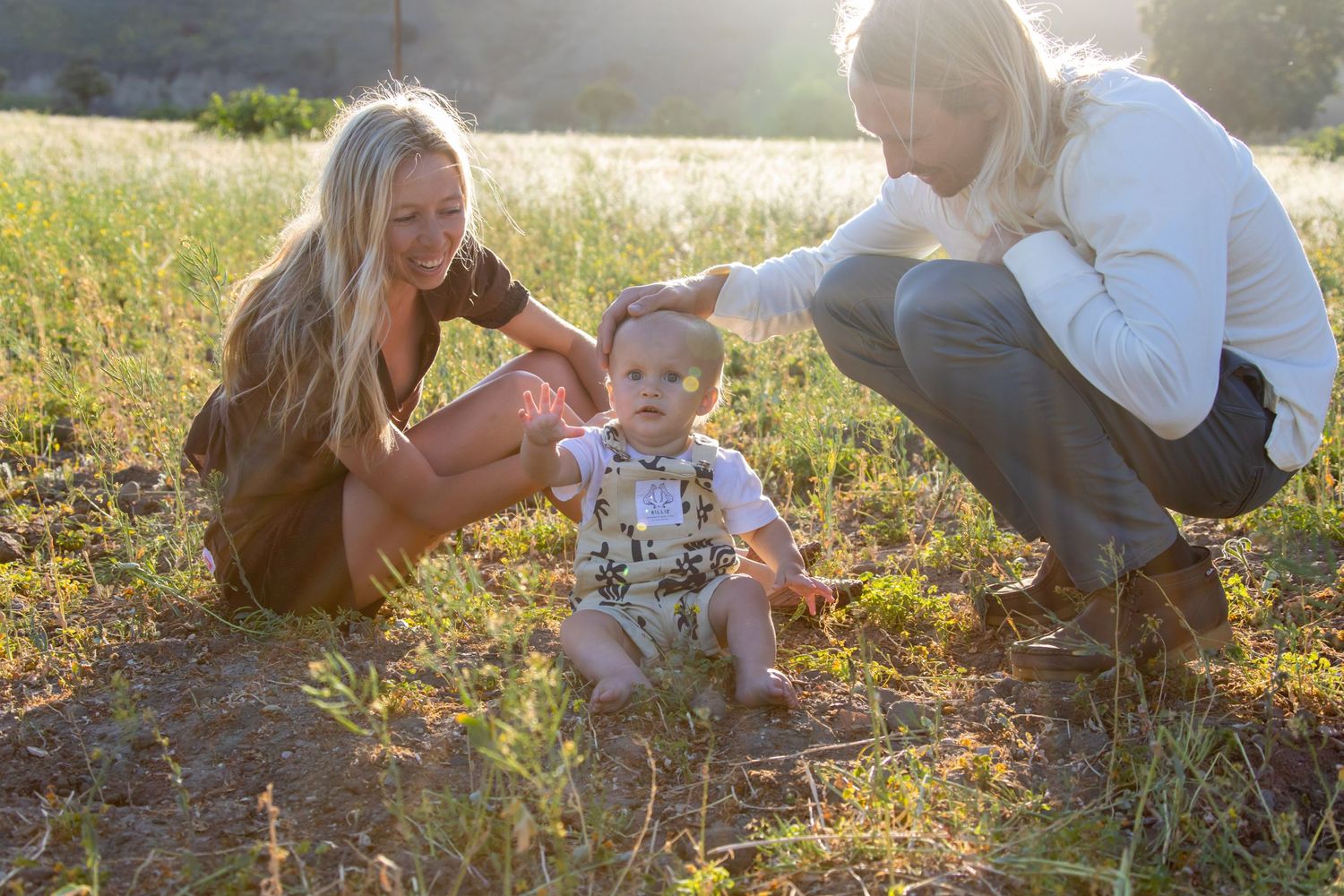 Natural lifestyle photography session in a golden meadow during magic hour.