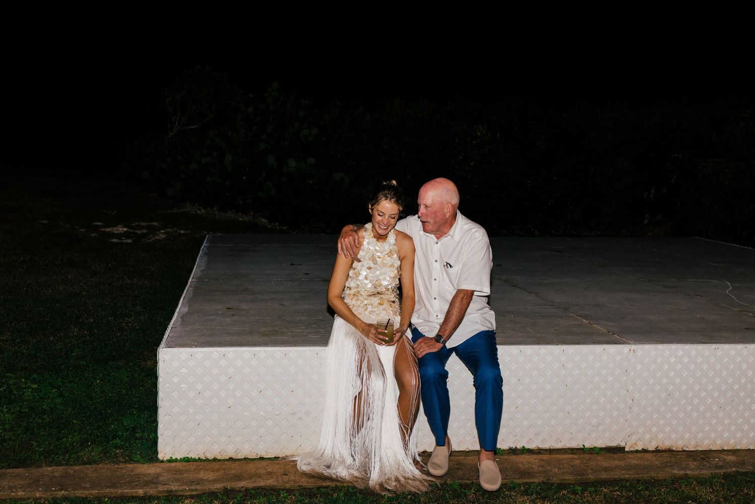 Couples dancing together at a nighttime outdoor wedding reception.