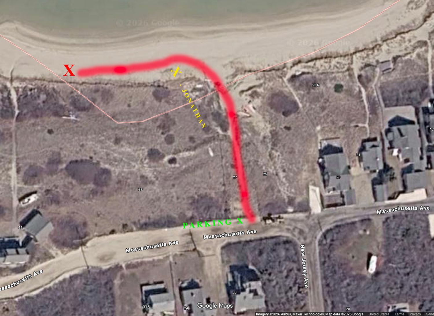 Aerial satellite map with red path marking a trail route near a beach, featuring X and arrow markers on coastal terrain.
