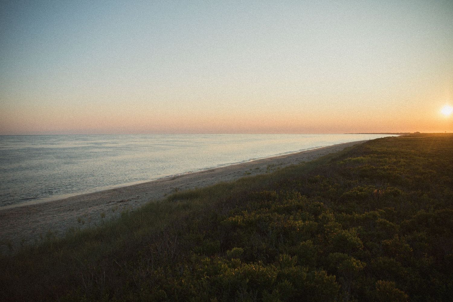 Scenic coastal sunset view over the ocean and beach landscape.