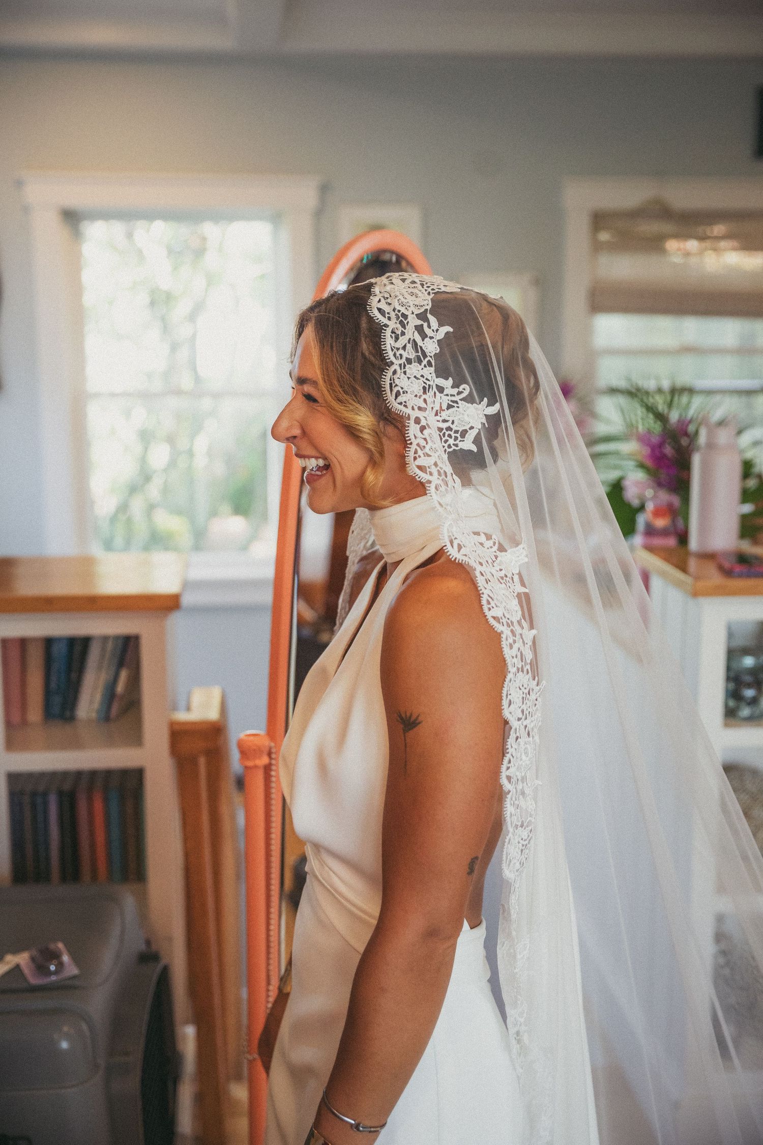 Elegant bridal portrait showing delicate lace veil details in natural window light.