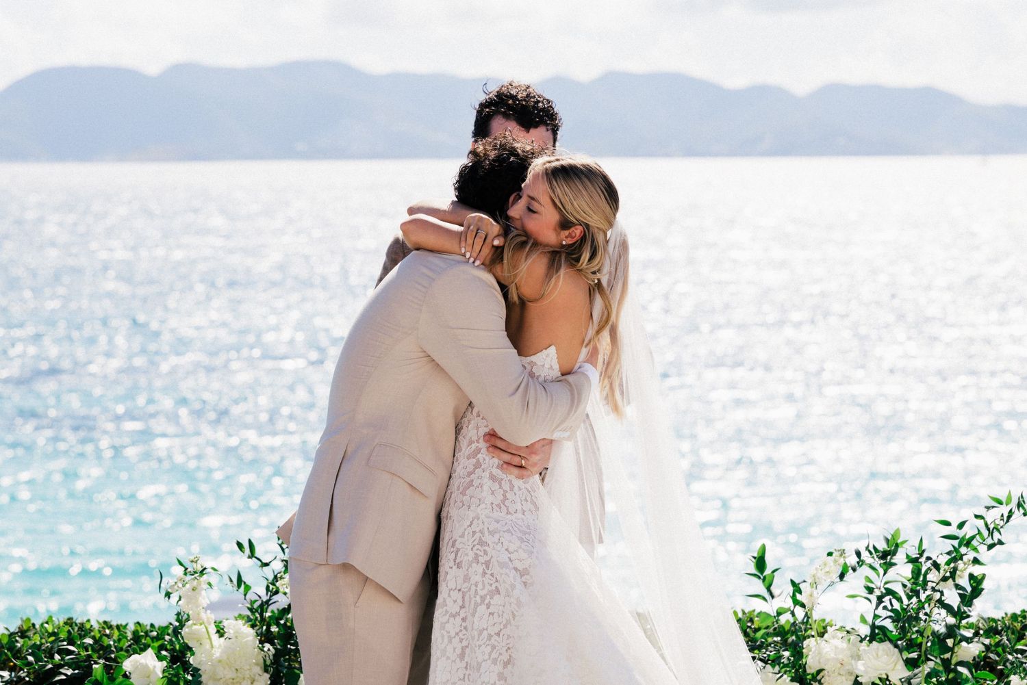 Beautiful oceanfront wedding ceremony with white flowers and natural coastal scenery.