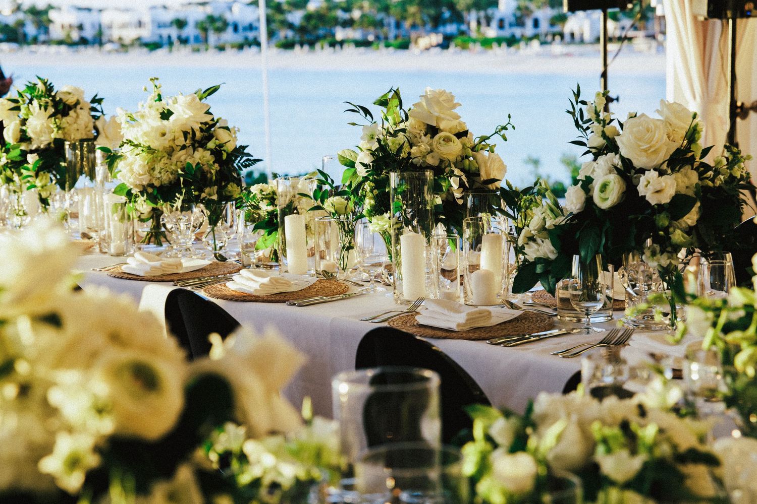 Elegant wedding reception table decorated with white flowers and greenery garlands.