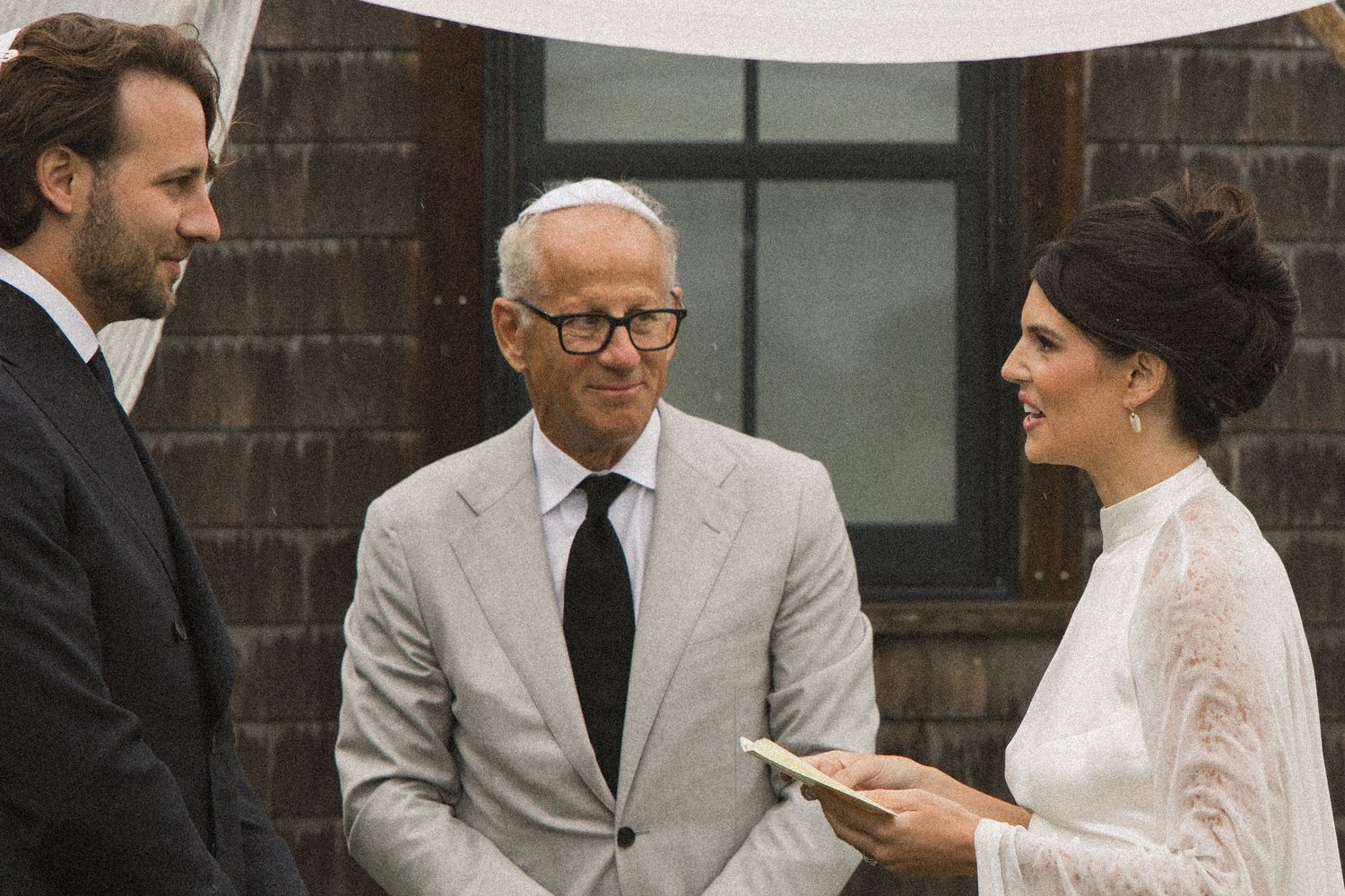 Bride and groom exchanging vows with officiant during an outdoor wedding ceremony.