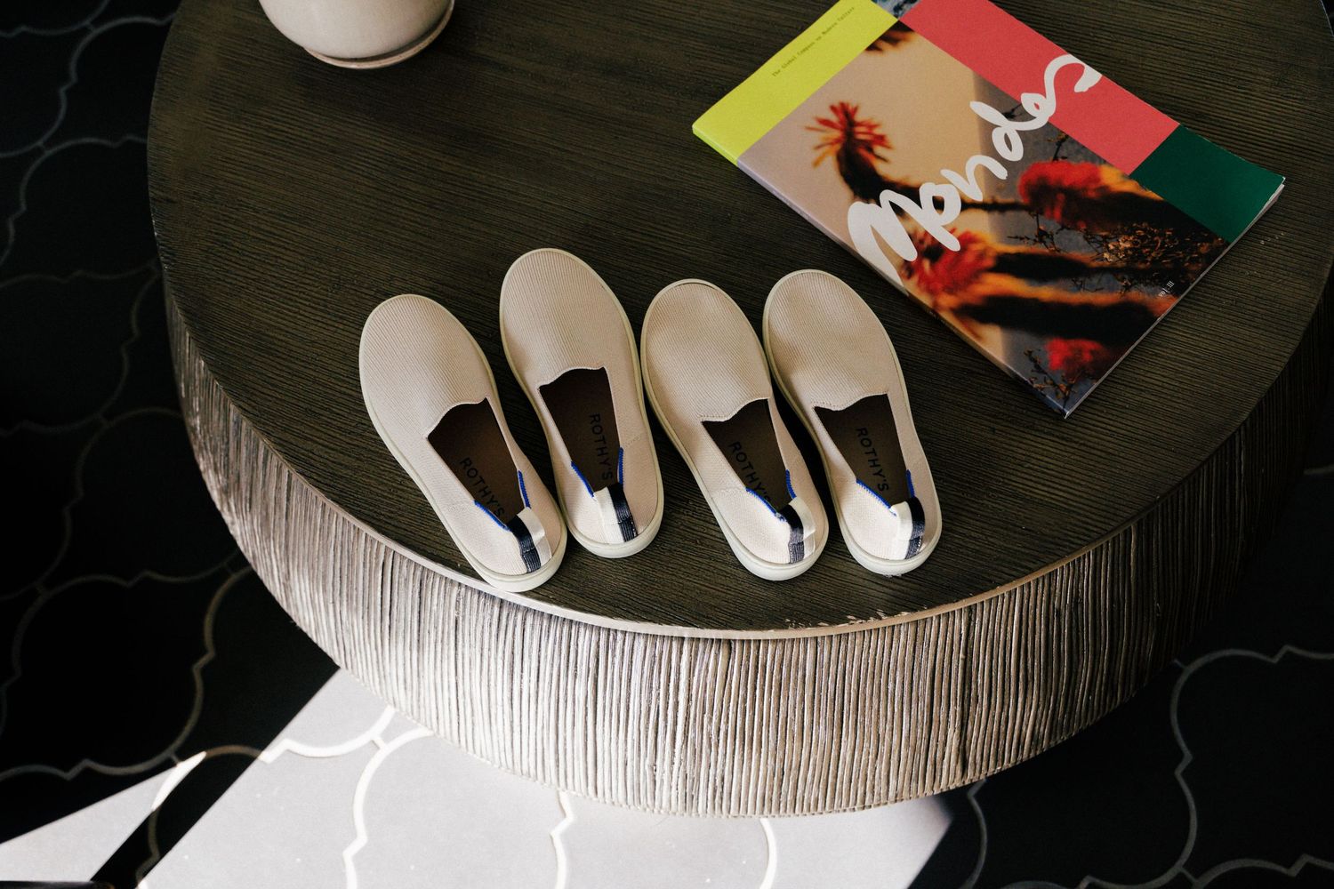 Dark wooden table with white place settings and decorative elements arranged on top.