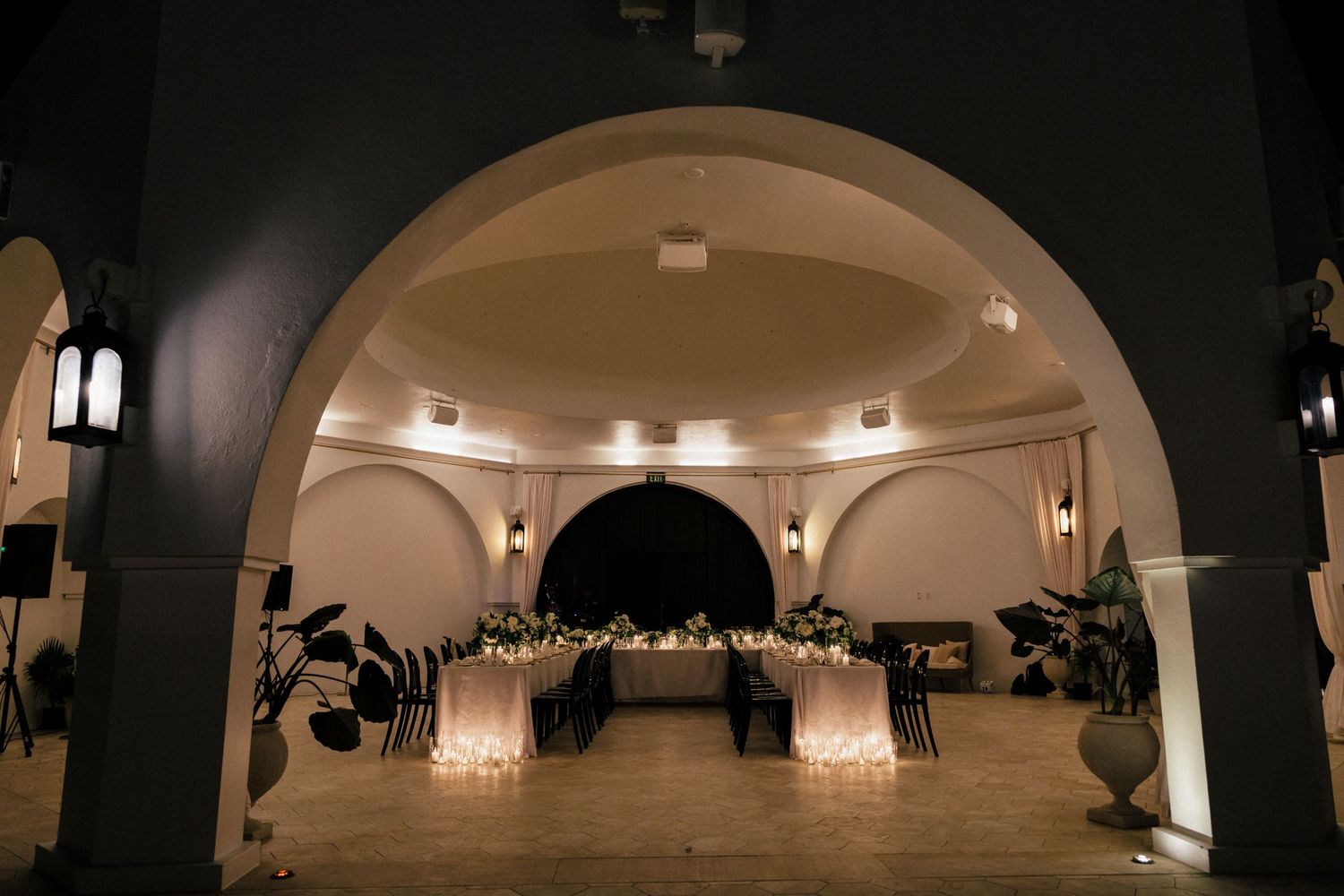 Elegant wedding reception venue with arched doorways and warm lighting creating a romantic atmosphere.