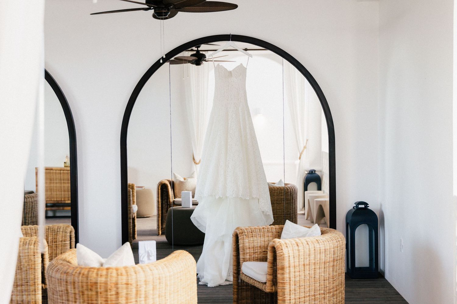Modern interior space with white walls, arched doorways and wicker furniture.