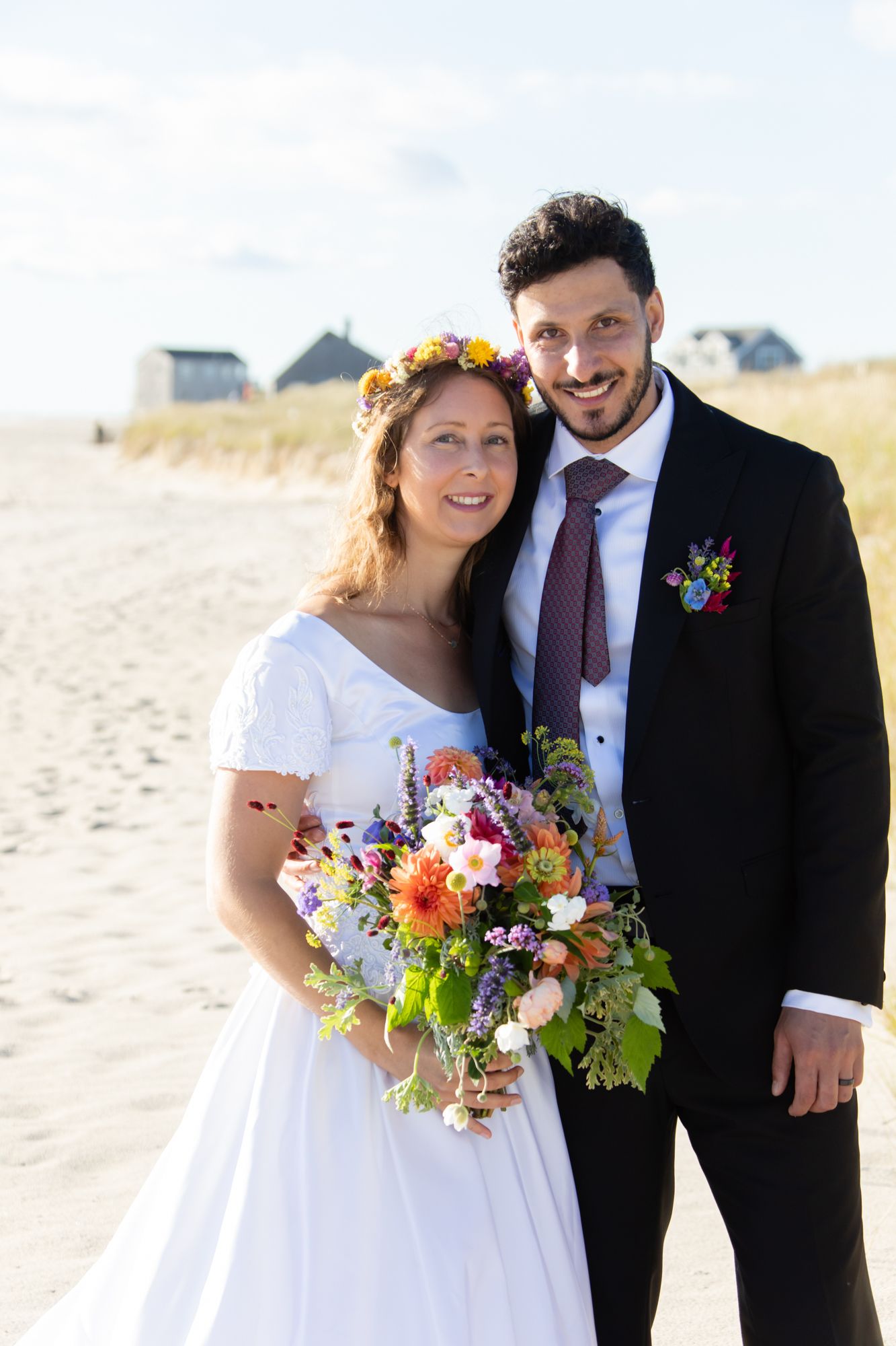 Beach wedding portraits featuring vibrant floral bouquets and coastal scenery.