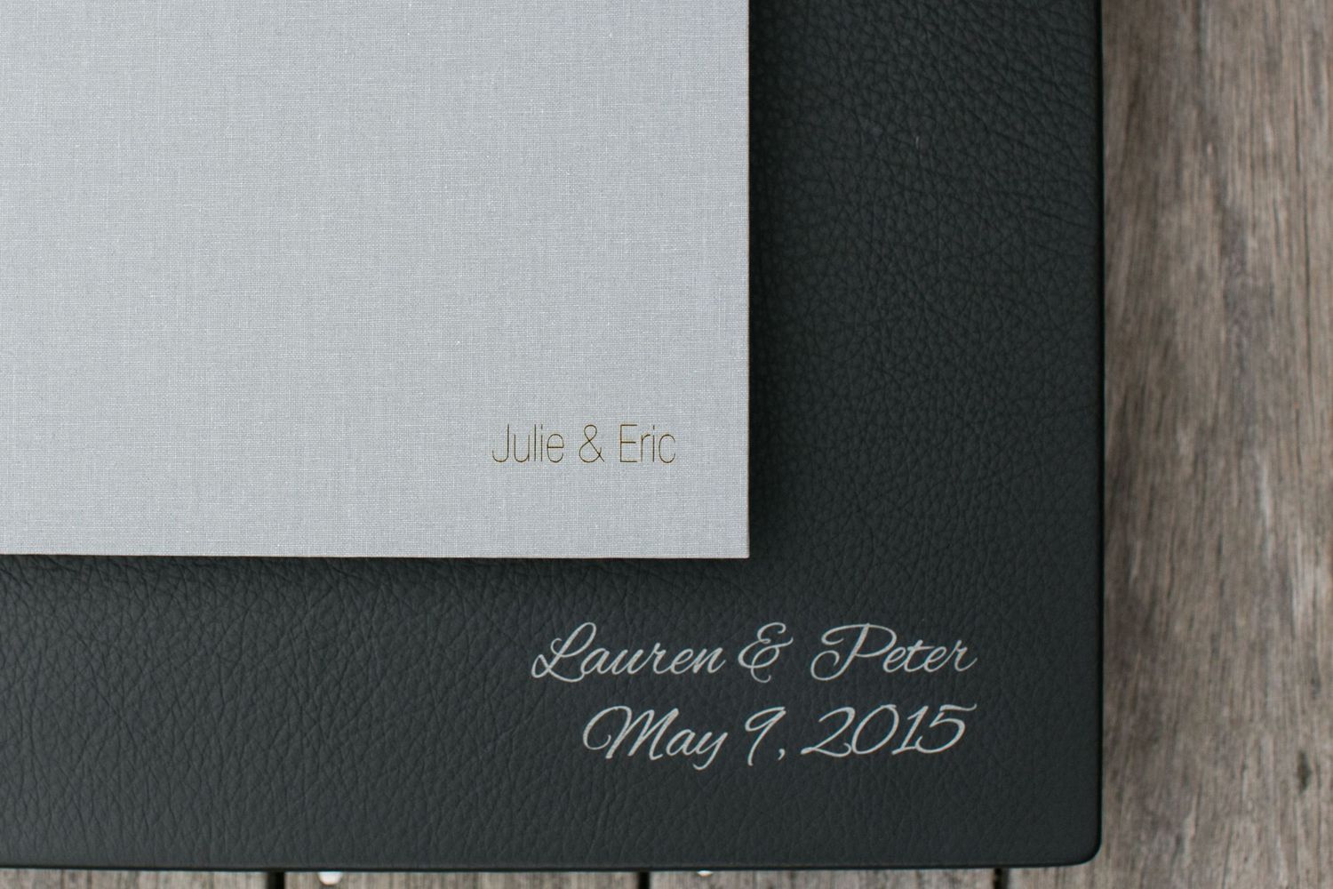 Close-up of photo album covers with engraved text and dates.