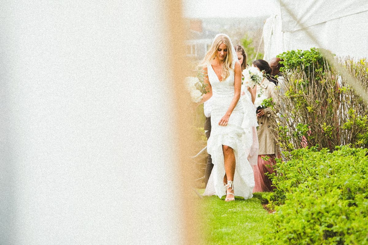 Garden wedding venue with lush greenery and white decorative elements.
