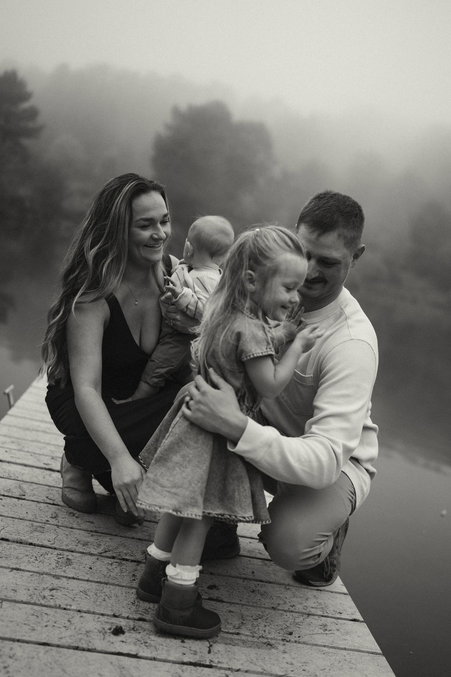 A candid moment captured on a wooden dock over a misty lake.