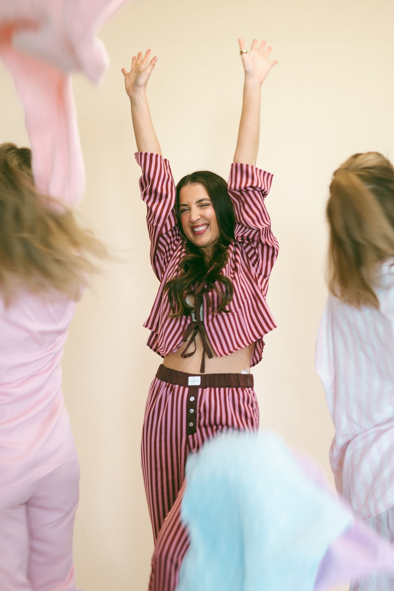 Friends jumping and celebrating together in casual clothing against a light background.