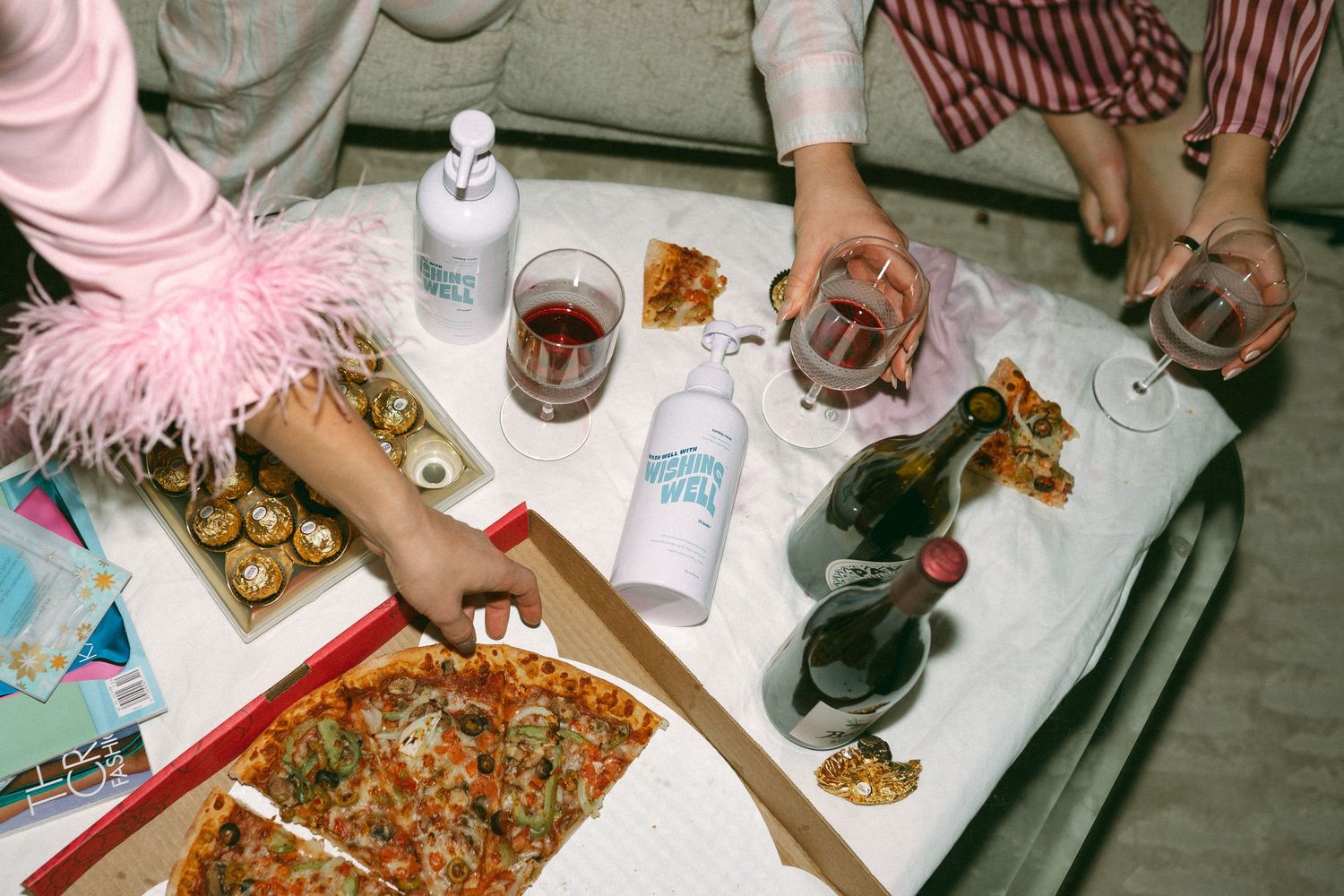 Table setting with pizza, drinks and appetizers at a casual dinner party.