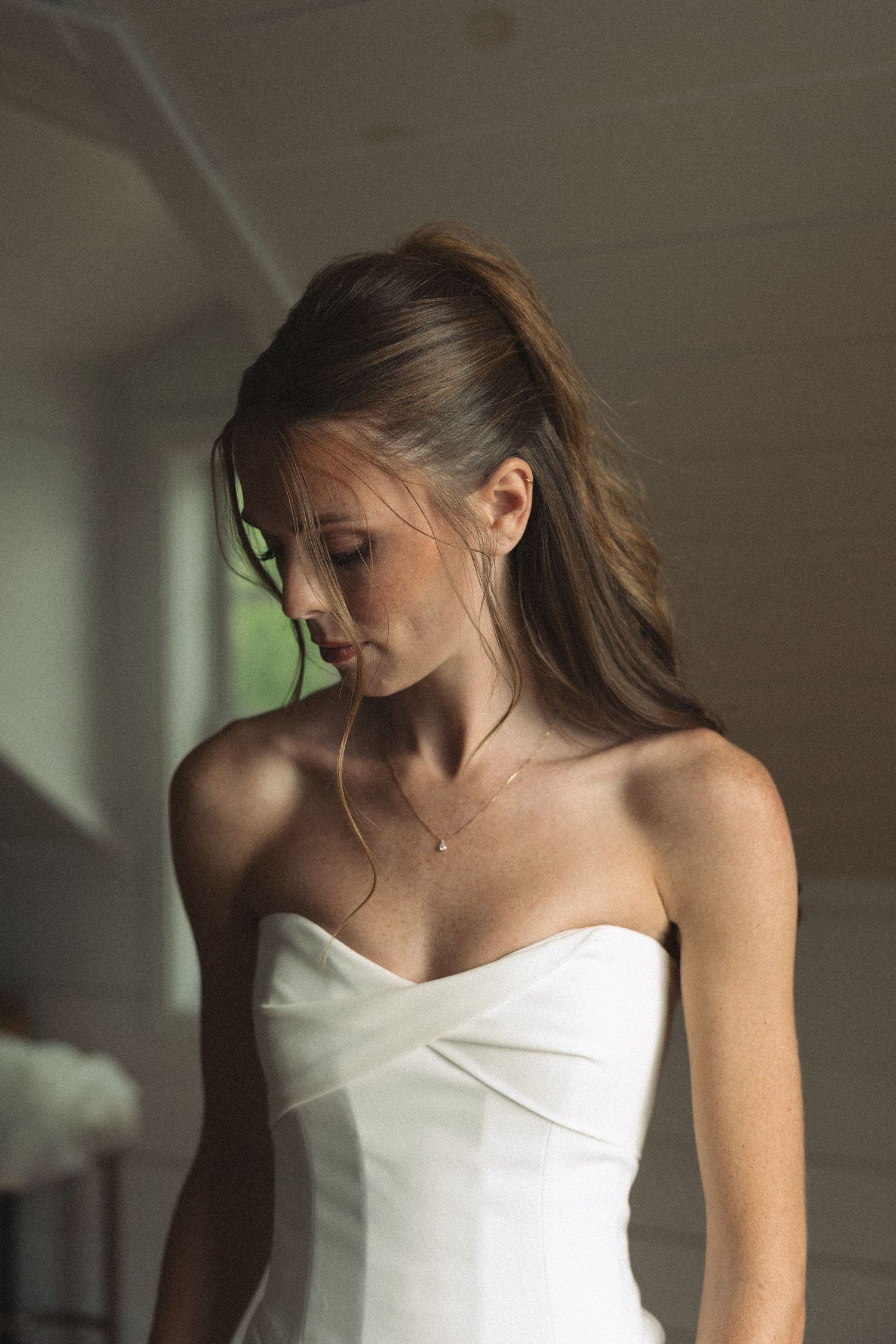 Elegant white strapless wedding dress photographed in soft natural light.