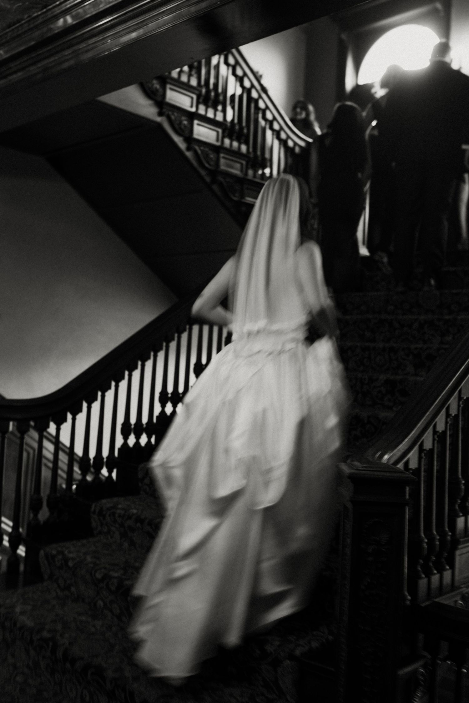 Dramatic black and white series of a bride descending a grand staircase in flowing wedding gown.
