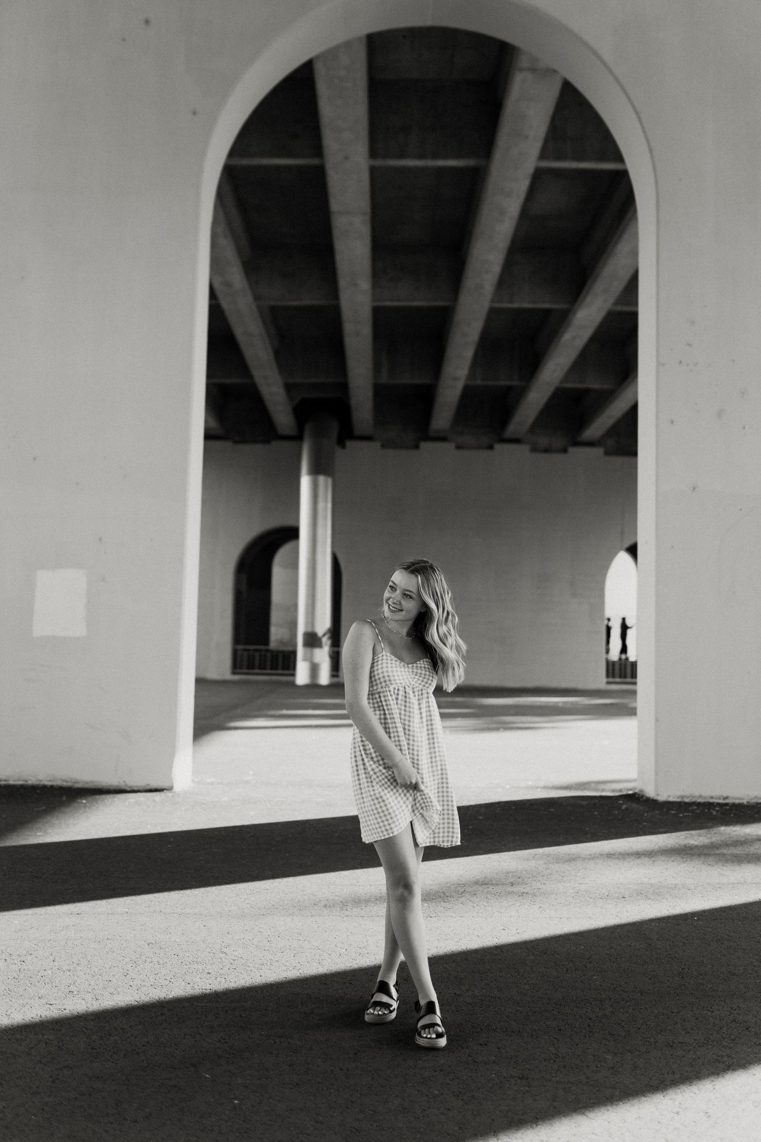 Black and white architectural photo under arched walkways creates dramatic shadows and light.