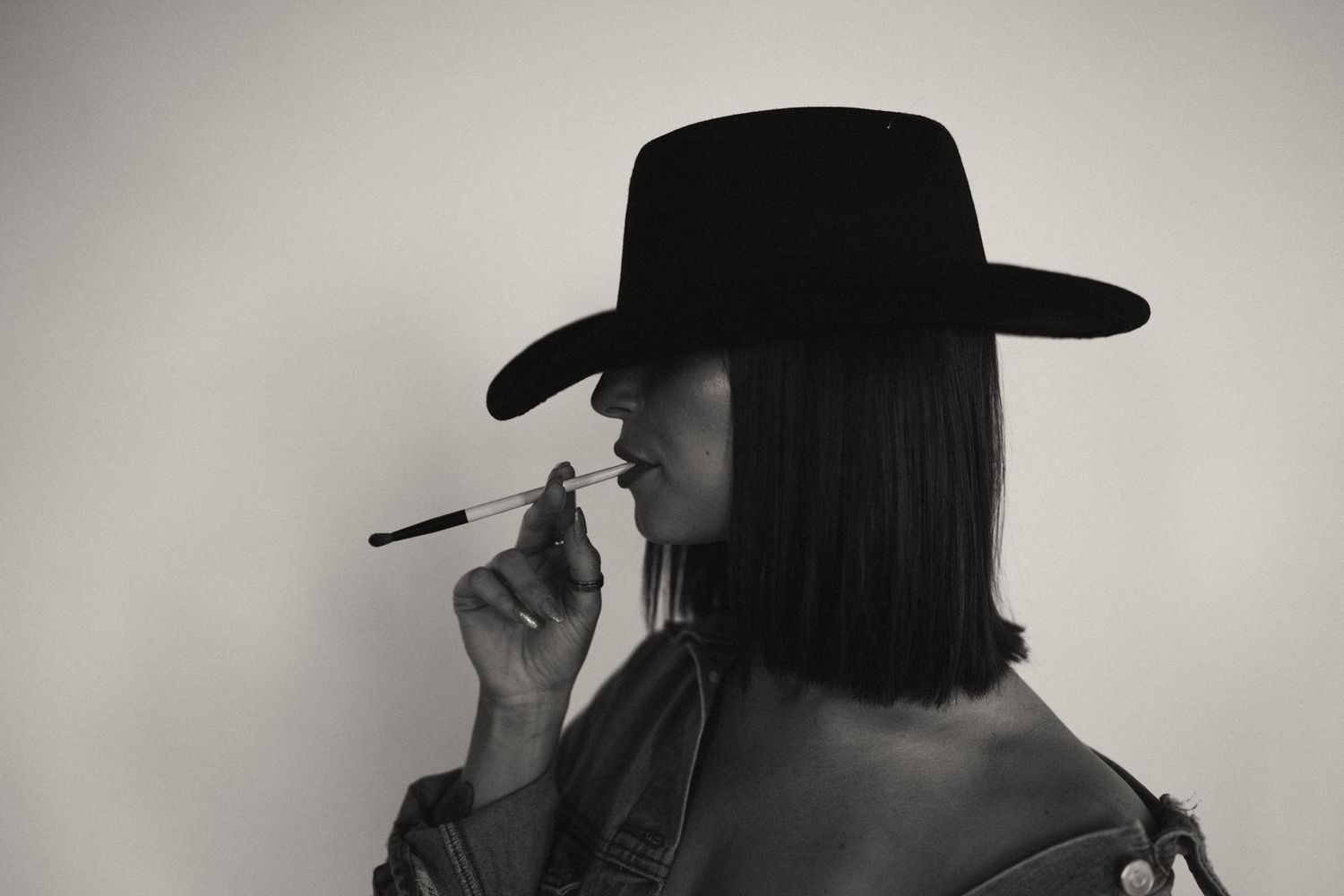 Dramatic black and white portraits featuring person in wide-brimmed hat.