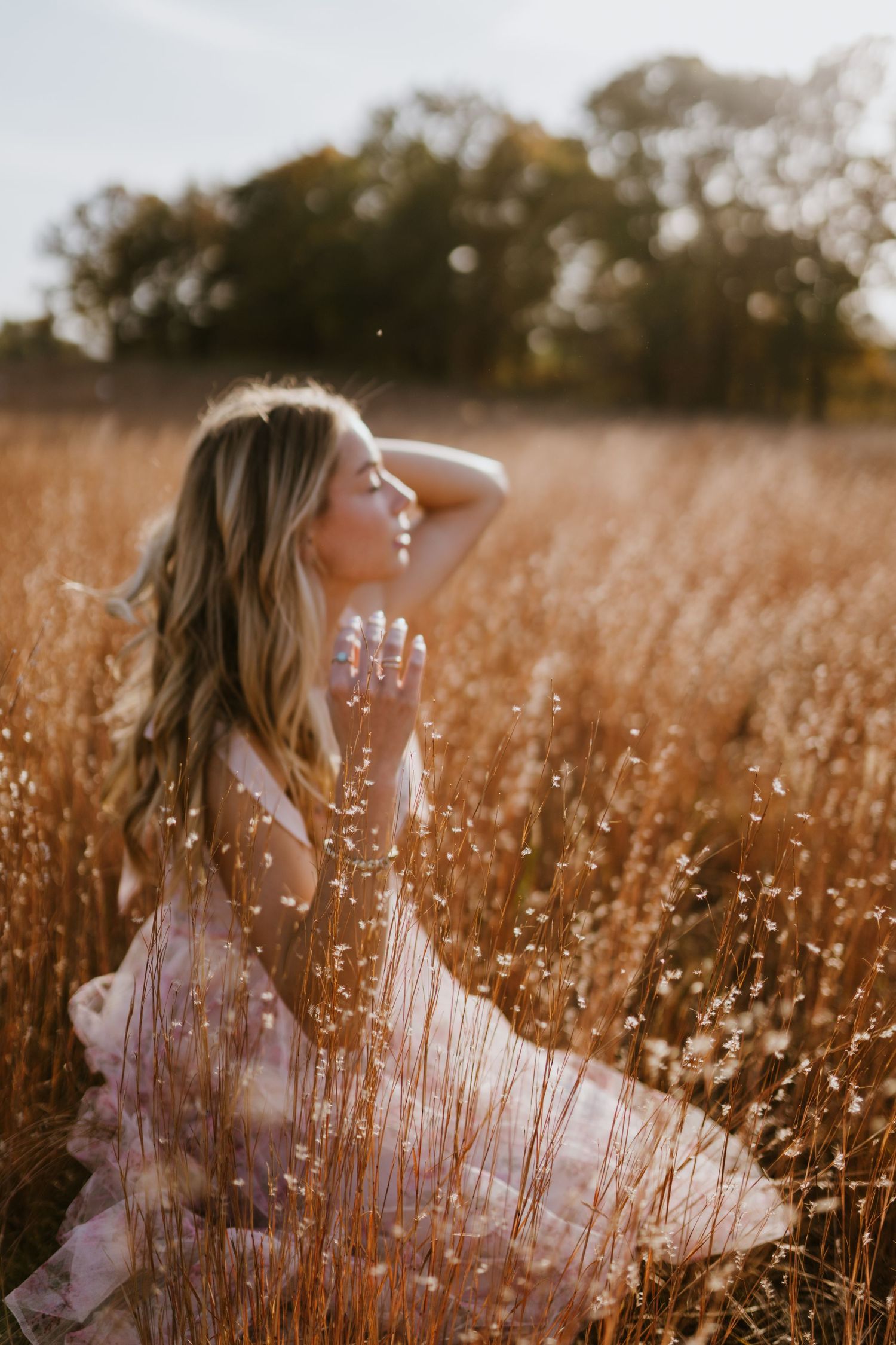 Ethereal sunset photography in a field of dried grass creates a romantic atmosphere.